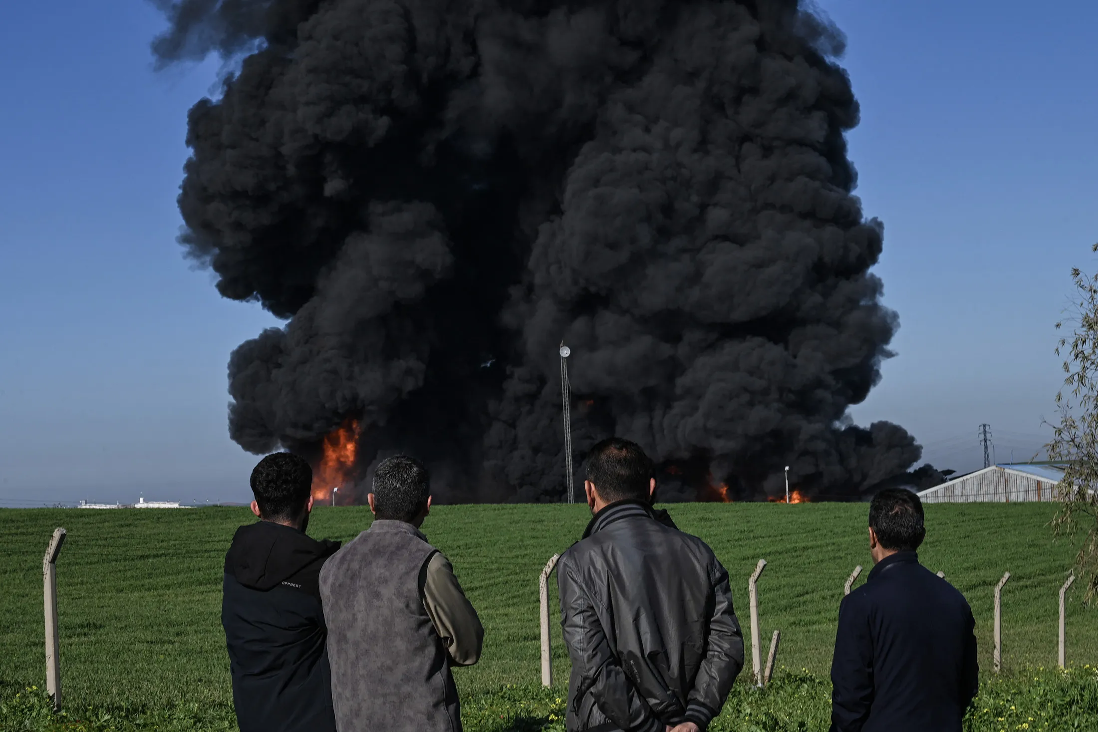 People watch as smoke billows from an oil warehouse following an airstrike&nbsp;in&nbsp;the outskirts of Erbil, the capital of Iraq's autonomous Kurdistan region, on April 1.