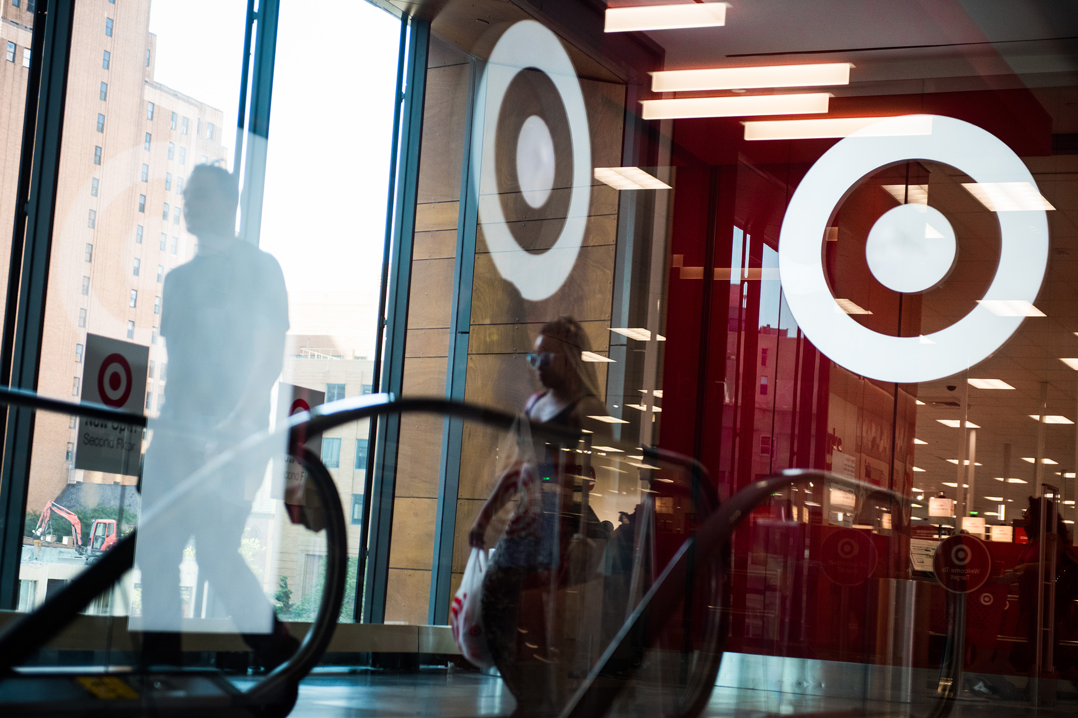 Pedestrians walk past the Target Corp. logo reflected in a window at City Point in the Brooklyn borough of New York, U.S., on Tuesday, July 18, 2017. Bloomberg is scheduled to release consumer comfort figures on July 20.
