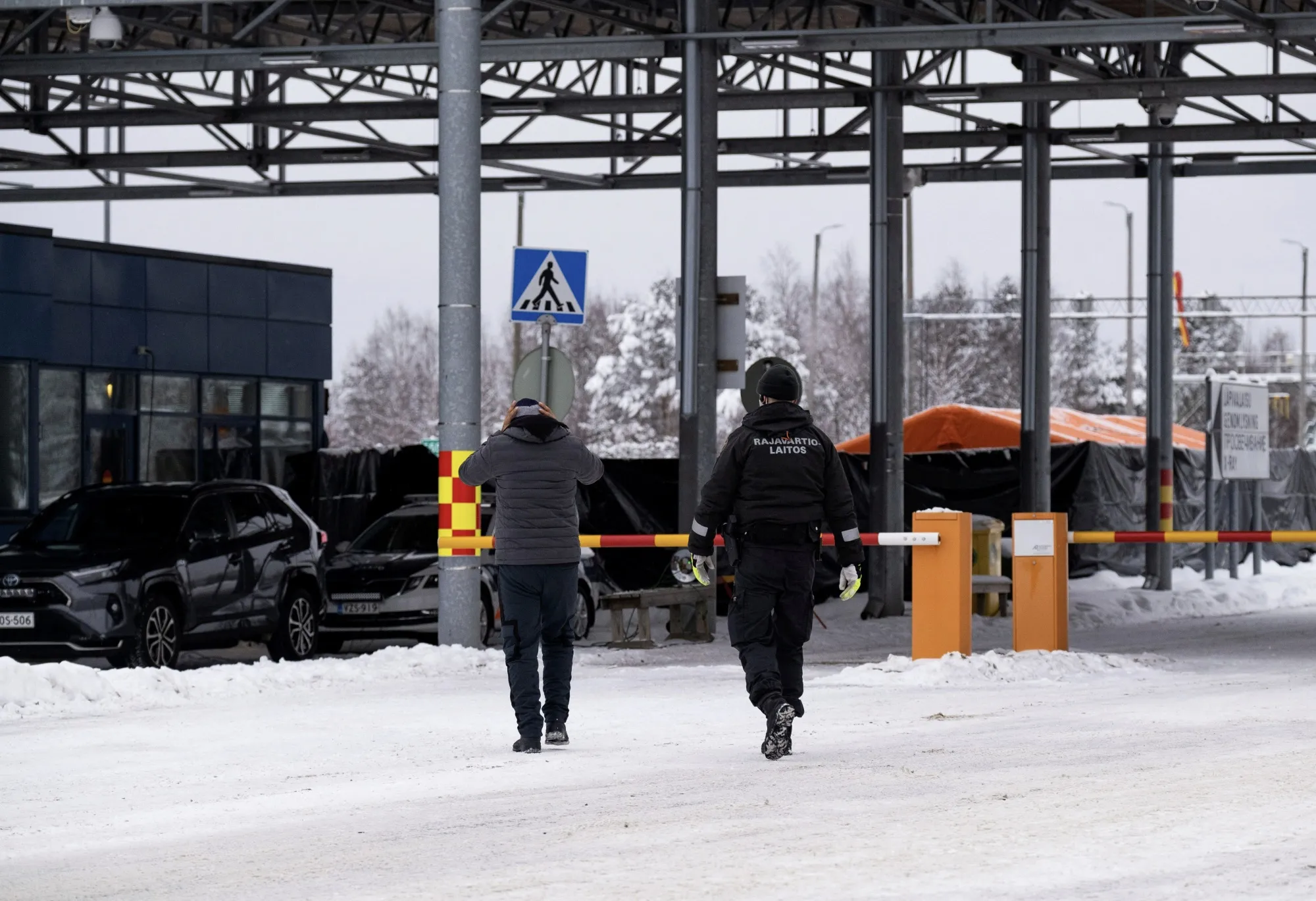 A border guard, left,&nbsp;escorts a migrant at the Niirala border check point between Finland and Russia in Tohmajärvi, Finland, in December.