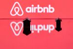 This illustration picture taken in Paris on August 29, 2018, shows toy houses next to the logo of rental website Airbnb.