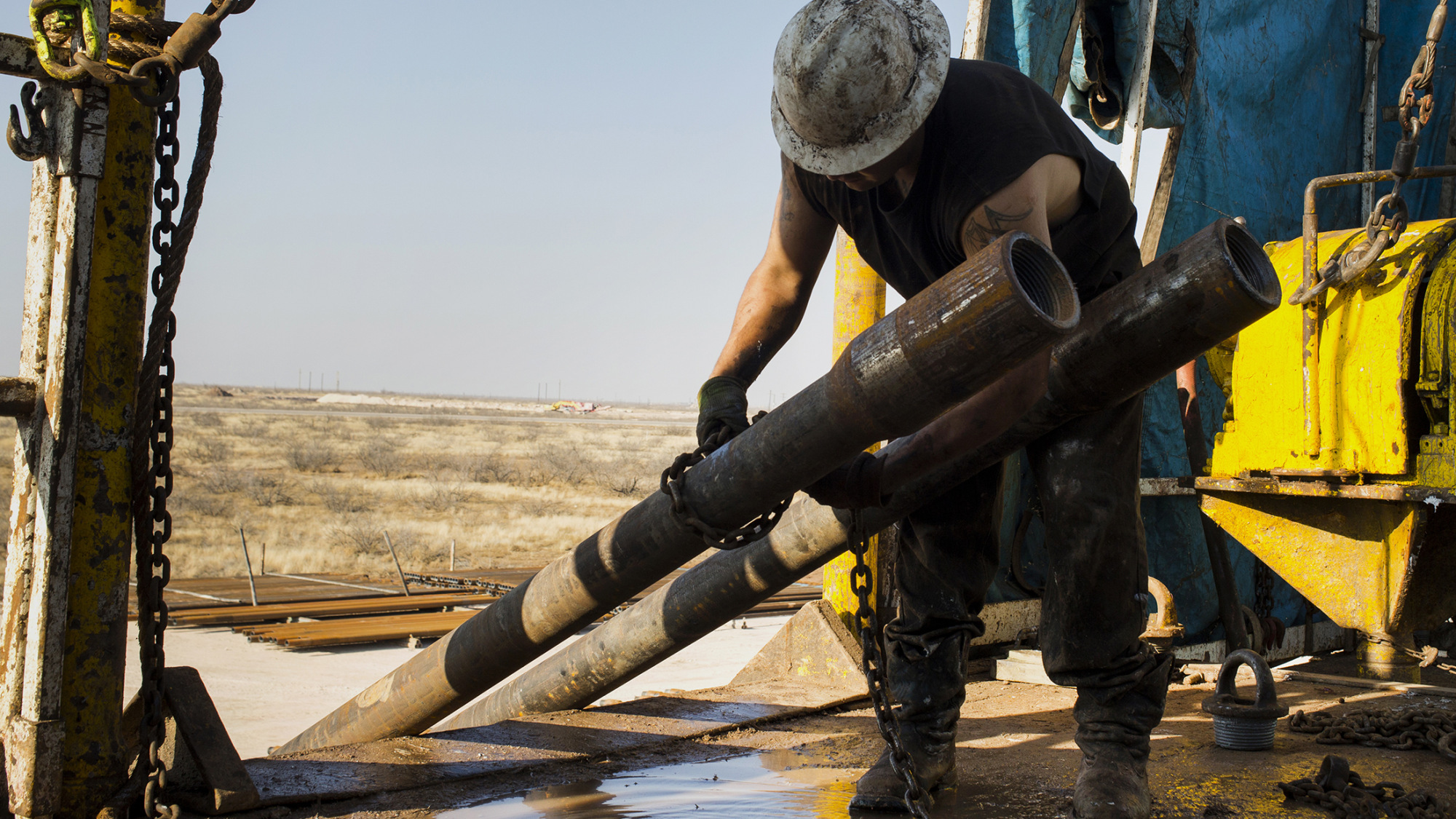A worker prepares to lift drills to the main floor of a rig in the Permian basin outside of Midland, Texas.
