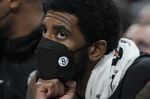 Brooklyn Nets' Kyrie Irving watches from the bench during the first half of the team's NBA basketball game against the Indiana Pacers, Wednesday, Jan. 5, 2022, in Indianapolis. (AP Photo/Darron Cummings)