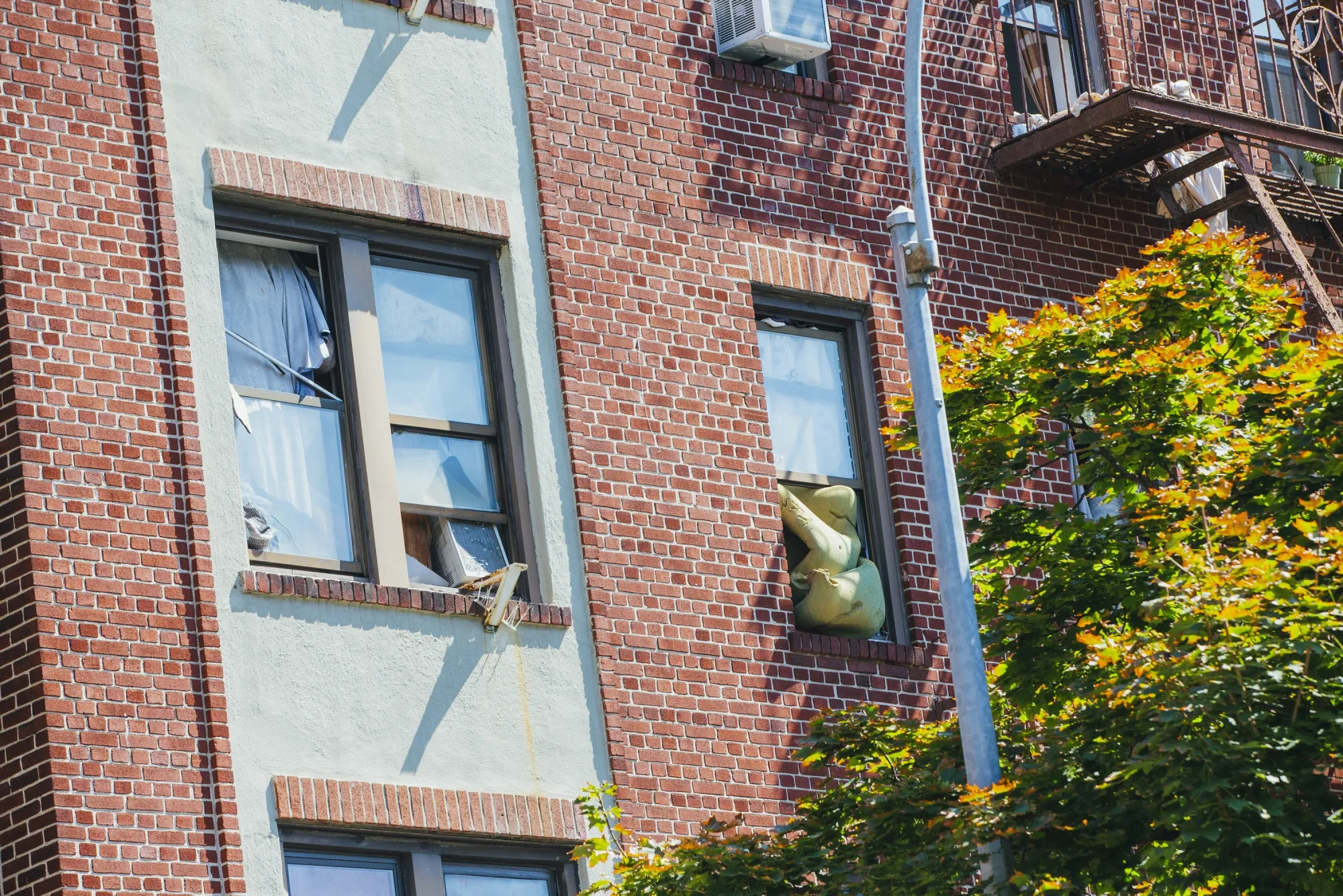 A cushion wedged&nbsp;into a window of a building in the Inwood neighborhood of New York.