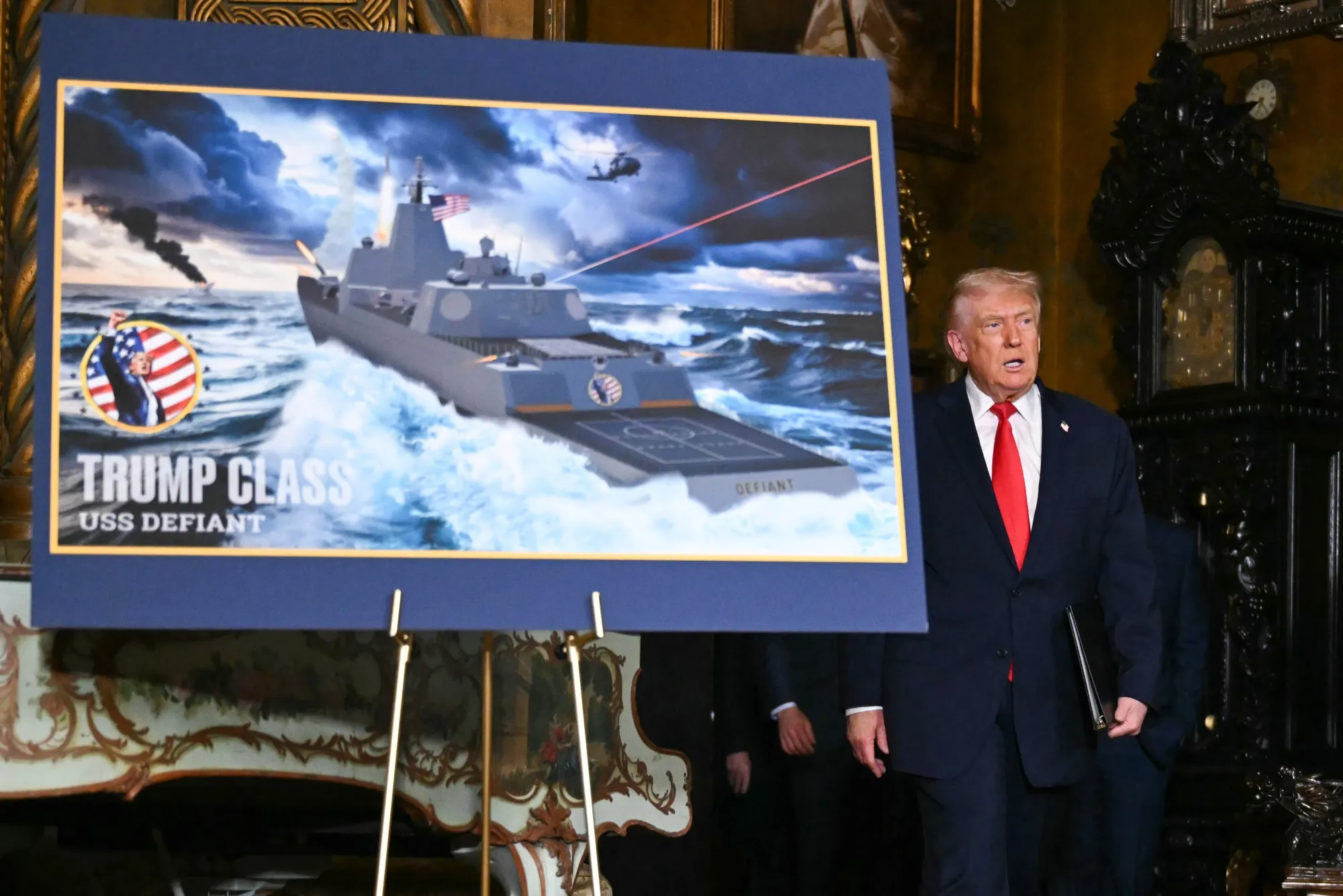 Trump with a poster of a new line of warships named after himself.