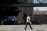 A pedestrian wearing a protective mask walks in downtown Dallas, Texas on Wednesday, May 27, 2020.