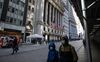 Pedestrians wearing protective masks pass in front of the New York Stock Exchange (NYSE) in the Financial District of New York, U.S., on Friday, March 5, 2021. Stocks climbed as technology shares rebounded from an earlier selloff.