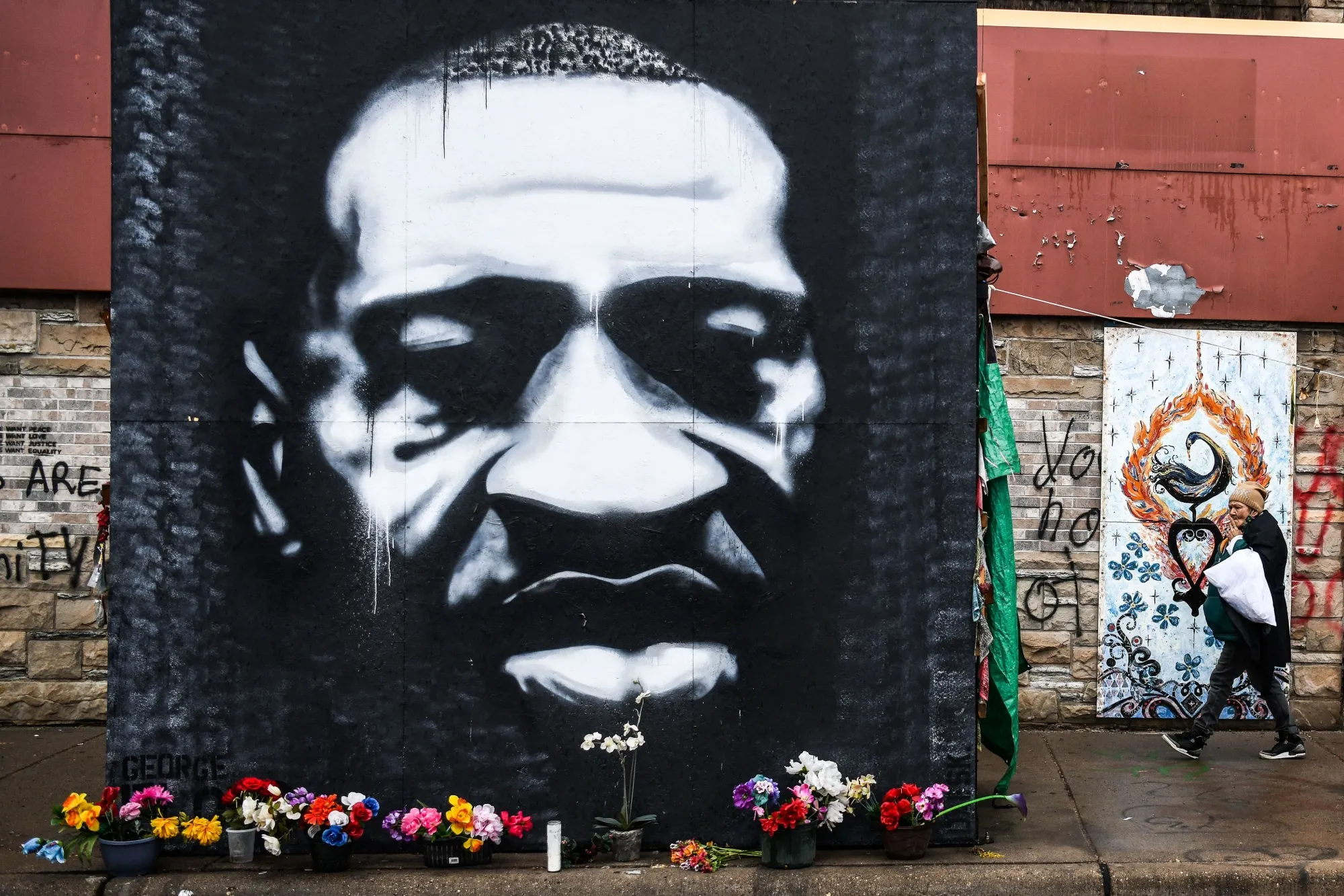 A woman walks near a makeshift memorial for George Floyd.&nbsp;