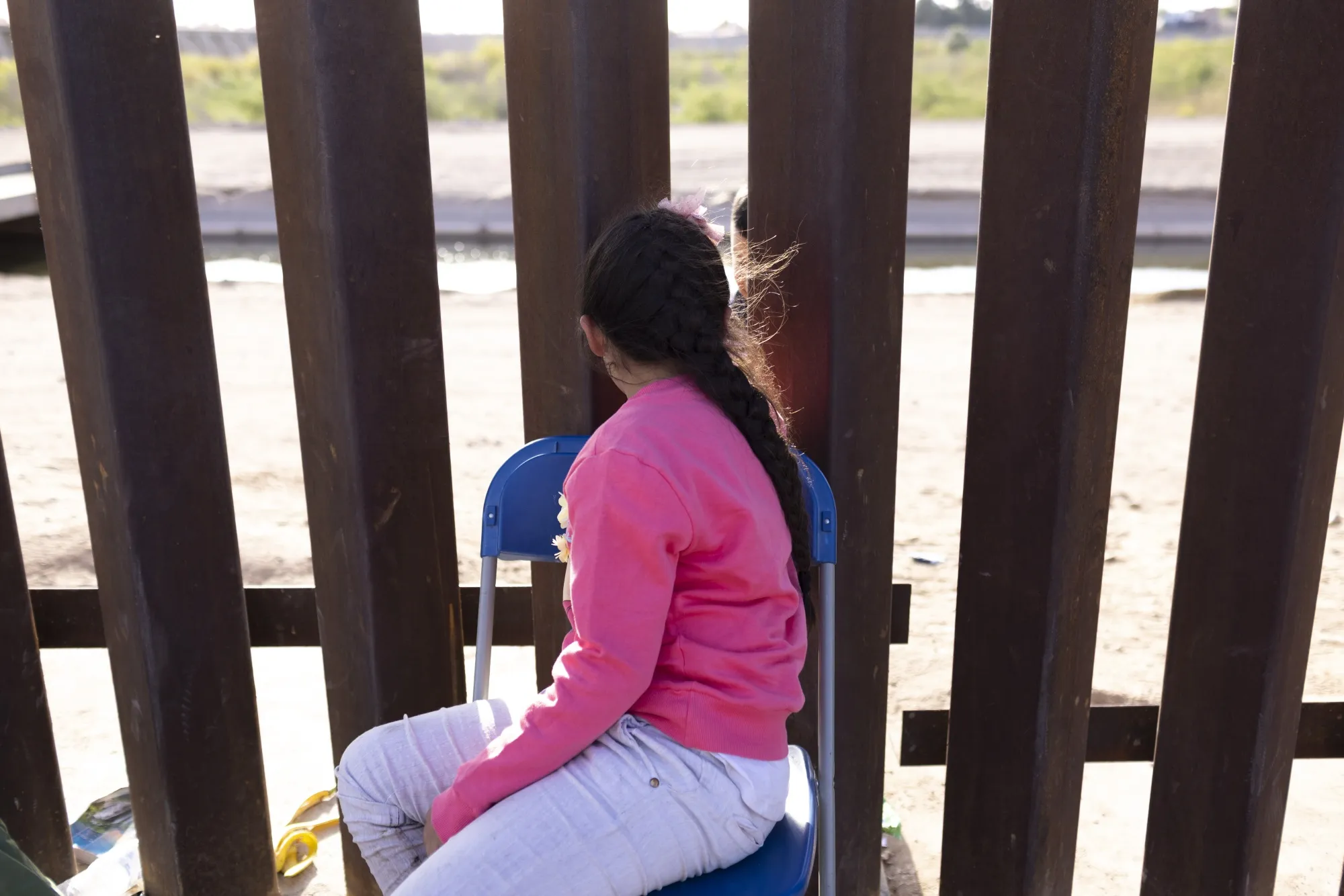 A migrant child seeking asylum waits to be processed by US&nbsp;Border Patrol agents after crossing the&nbsp;border in Yuma, Arizona.