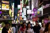 Pedestrians walk past illuminated store signs at night in the Myeongdong shopping district of Seoul, South Korea, on Friday, June 28, 2019. South Korea is scheduled to release consumer price index (CPI) figures on July 2.