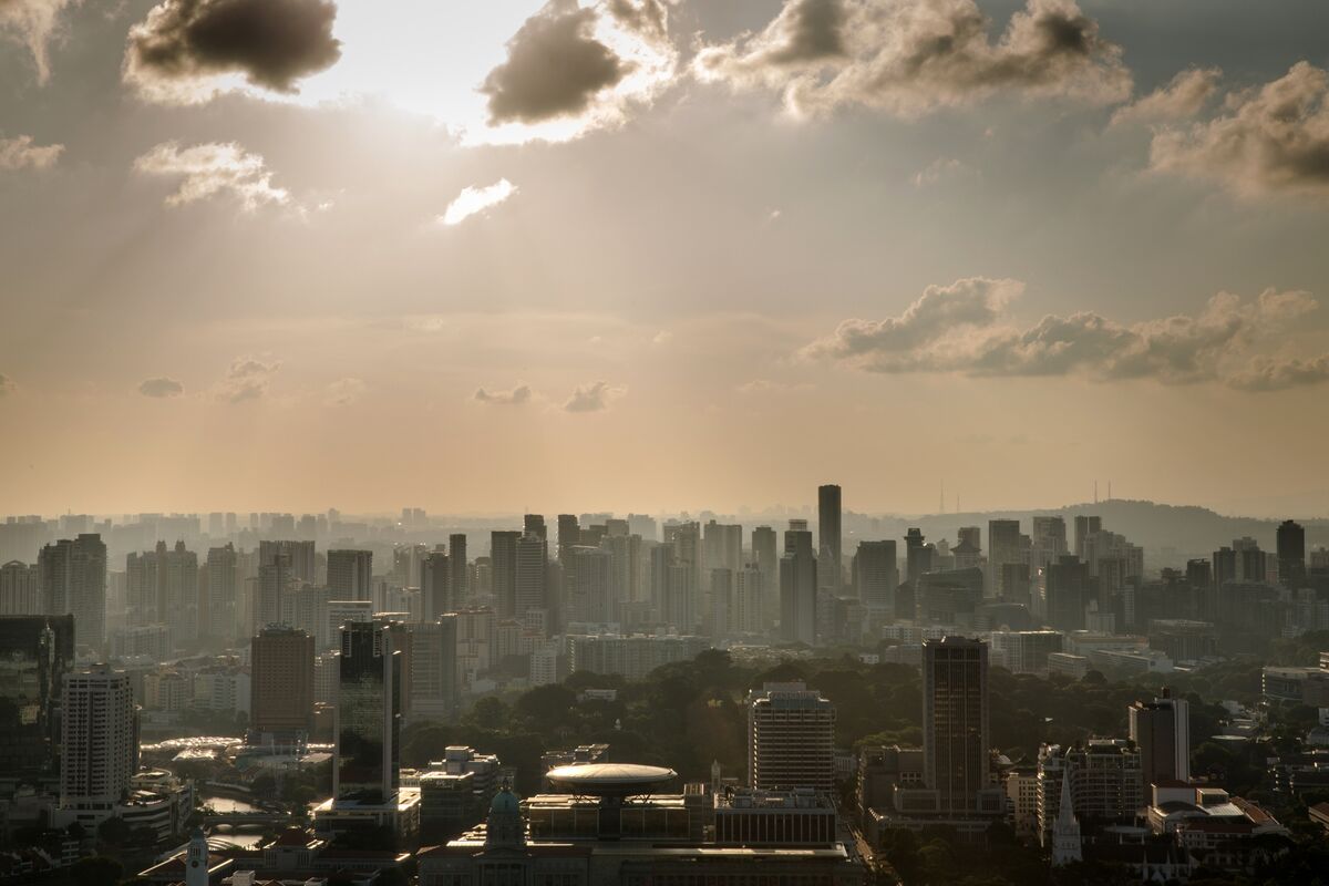 Skyline of Singapore's central business district with the sun breaking through the clouds