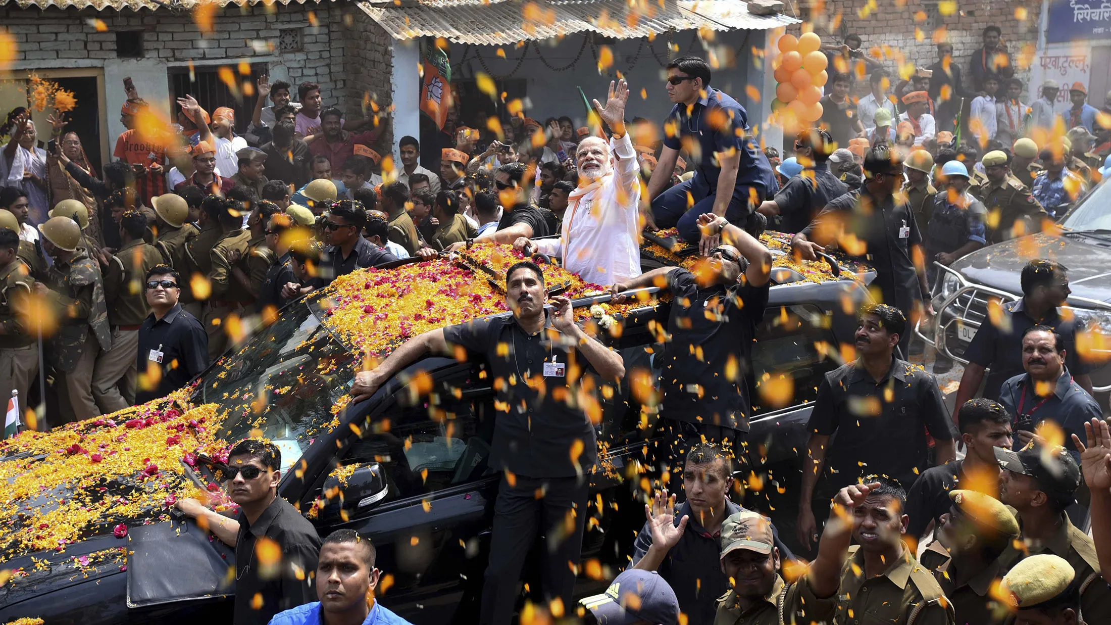 VARANASI, INDIA - MARCH 4: Prime Minister Narendra Modi during the road show on March 4, 2017 in Varanasi, India. On a busy day in his Lok Sabha constituency to rally voters around the Bharatiya Janata Party (BJP) in eastern Uttar Pradesh, Prime Minister Narendra Modi led a road show, offered prayers at two historic temples and paid tributes to Hindutva ideologue Pandit Madan Mohan Malviya.
