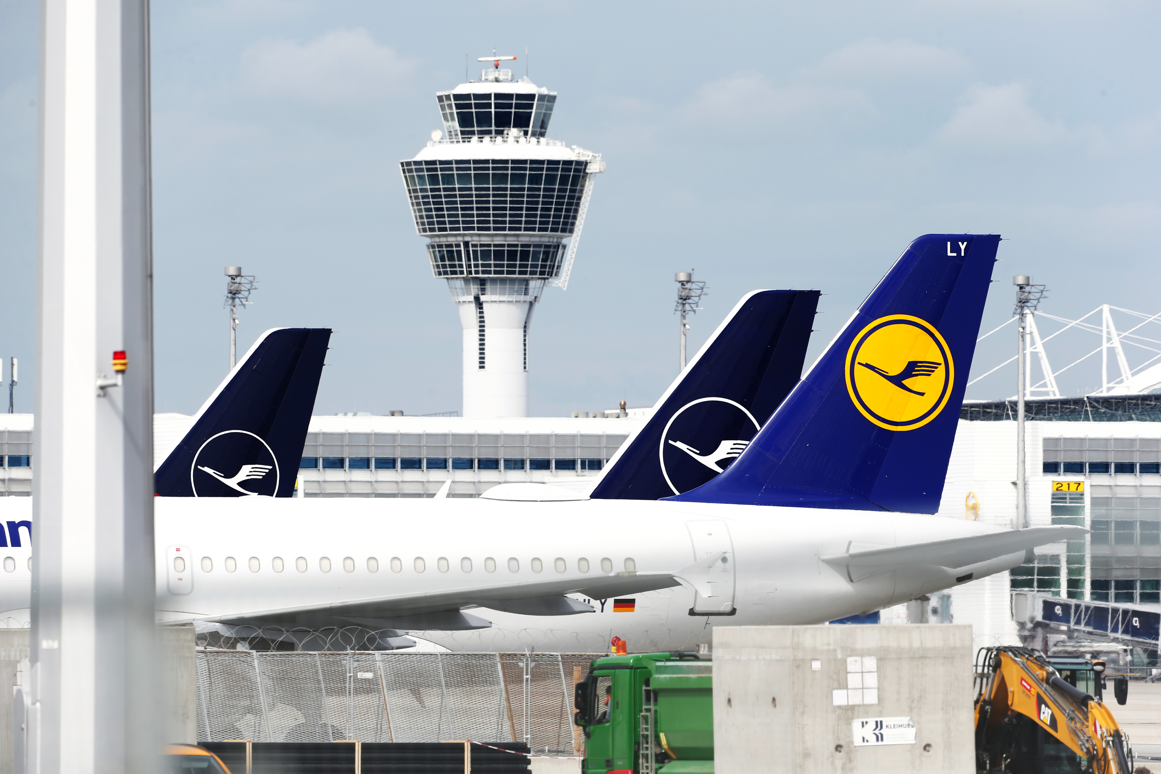 Grounded Deutsche Lufthansa AG passenger aircraft sit near the control tower at Munich Airport.