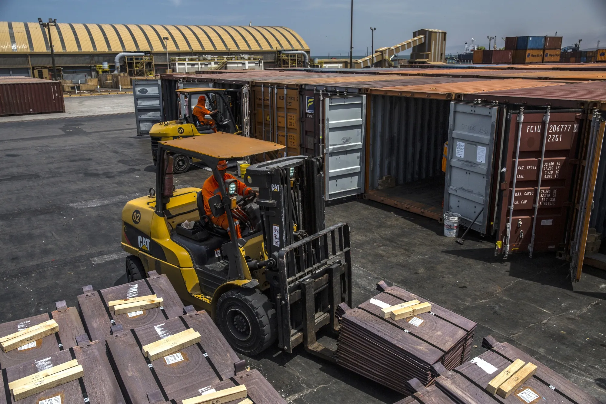 Longshoremen&nbsp;fill shipping containers with copper plates at a&nbsp;copper refinery and smelting facility.&nbsp;