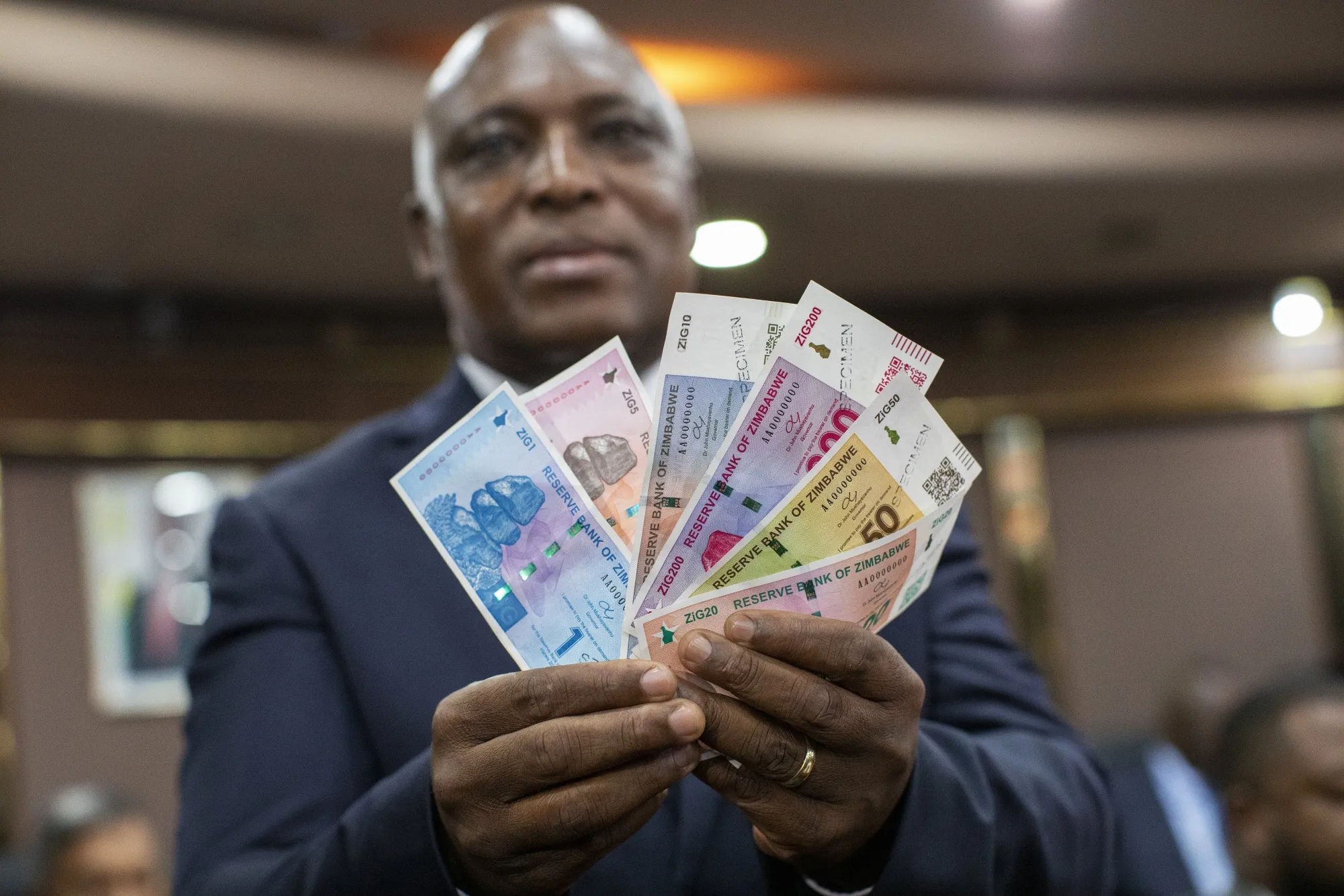 John Mushayavanhu, the governor of Zimbabwe’s central bank, holds up new&nbsp;ZiG notes.&nbsp;