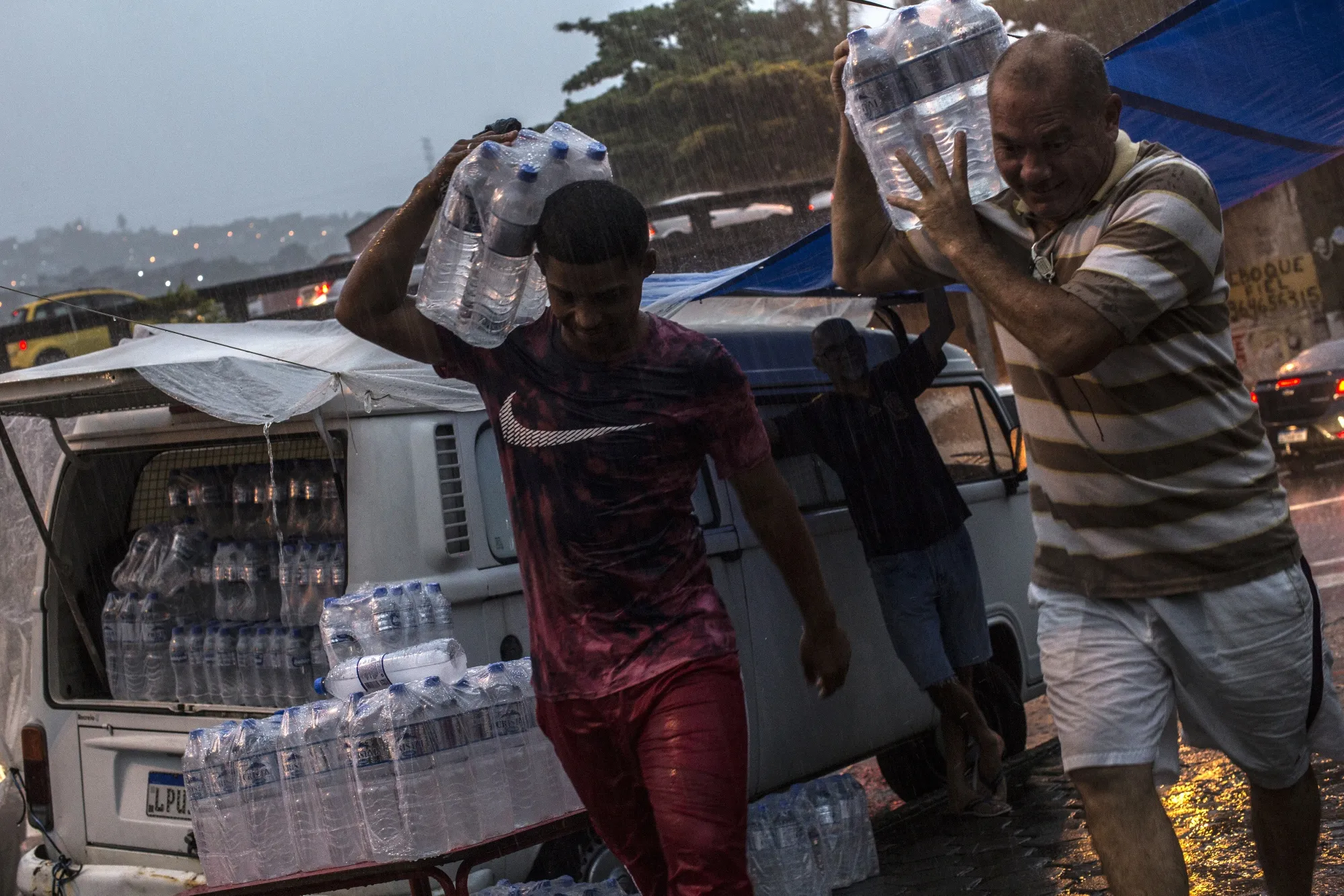 A street vendor helps a buyer with his water bottles after a purchase near Rio de Janeiro.