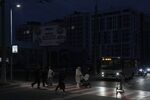 Pedestrians cross a street during a blackout in Chernigiv, Ukraine. Photographer: Andrew Kravchenko/AFP/Getty Images