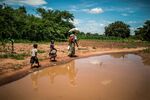 A woman and her children walk back home after collecting food aid&nbsp;in Simumbwe, Zambia, in January.