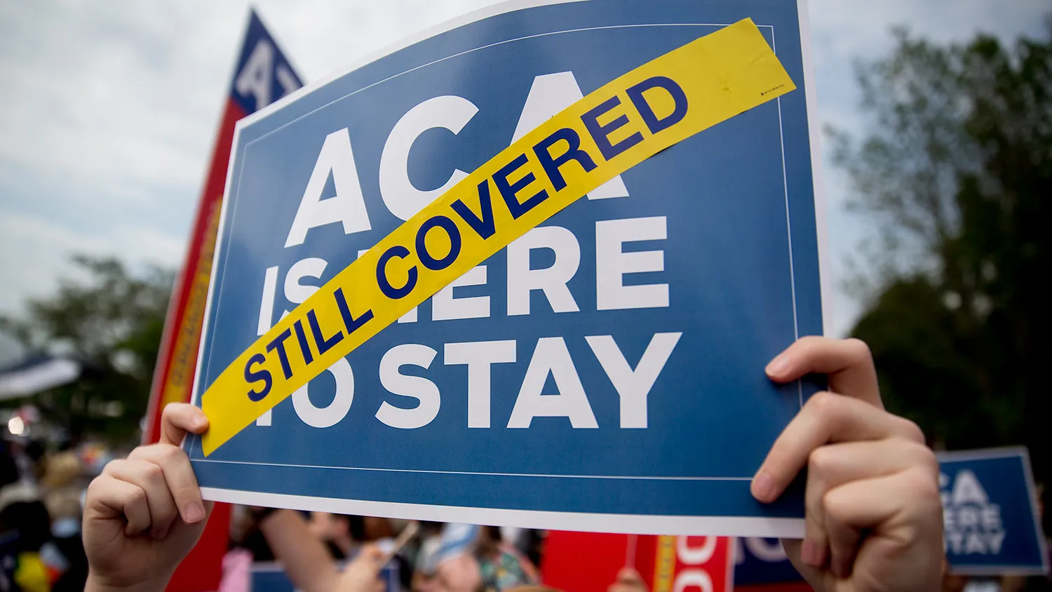 A demonstrator in support of President Barack Obama's health-care law, the Affordable Care Act (ACA), holds up a sign outside the Supreme Court in Washington on June 25, 2015.
