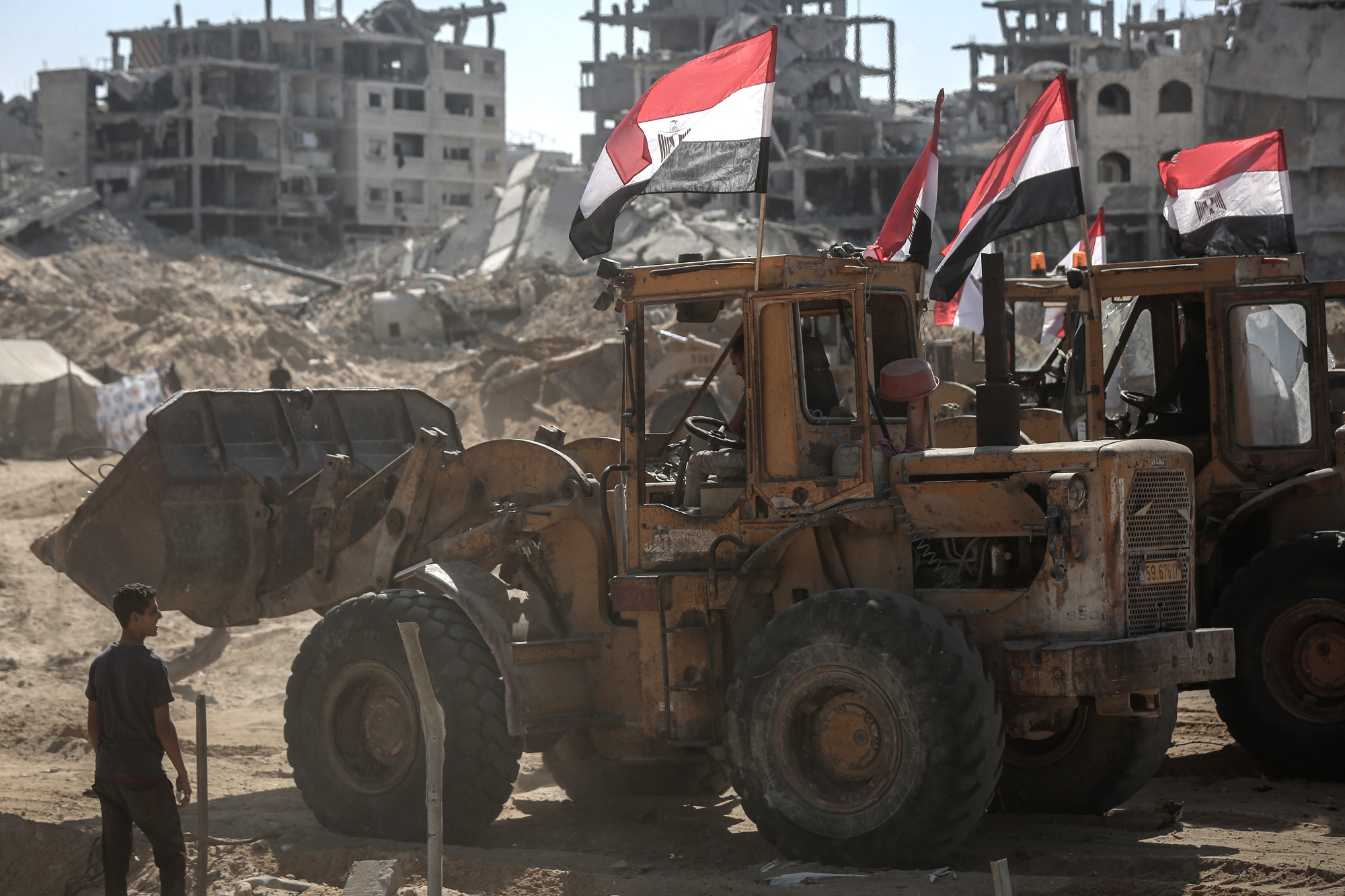Bulldozers carrying Egyptian flags clear ground near destroyed buildings in Gaza City, Gaza, on Sunday, Oct. 19, 2025. Israel said it has resumed a truce with Hamas in Gaza after heavy fighting over the weekend, with the sides accusing each other of breaching a deal brokered by US President Donald Trump. Photographer: Ahmad Salem&#x2F;Bloomberg