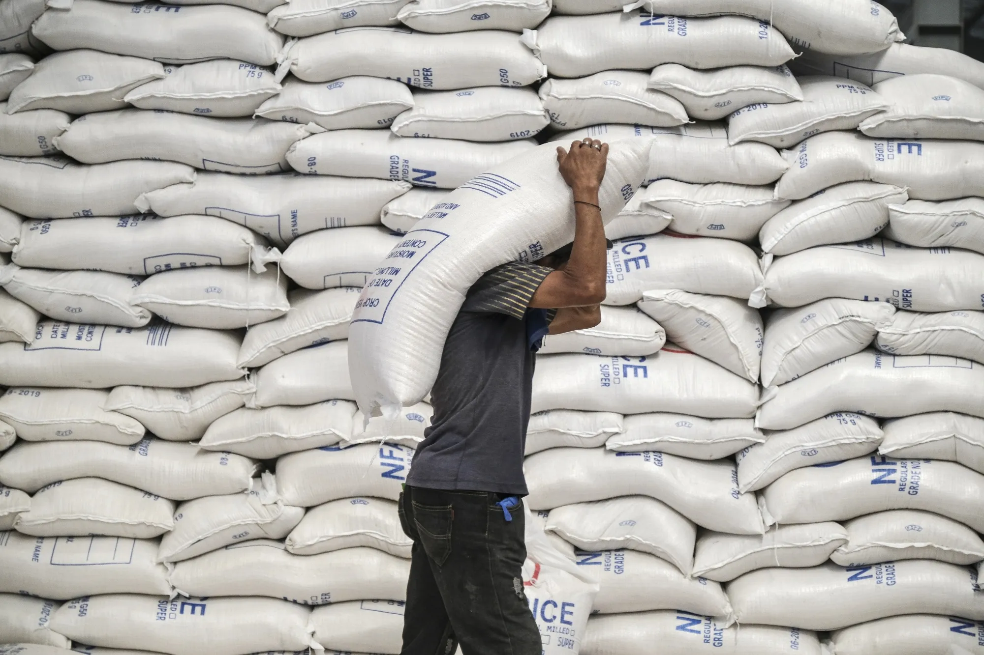 A worker carries a sack of rice in Manila.&nbsp;Rice is more popular with many Asian consumers than wheat.