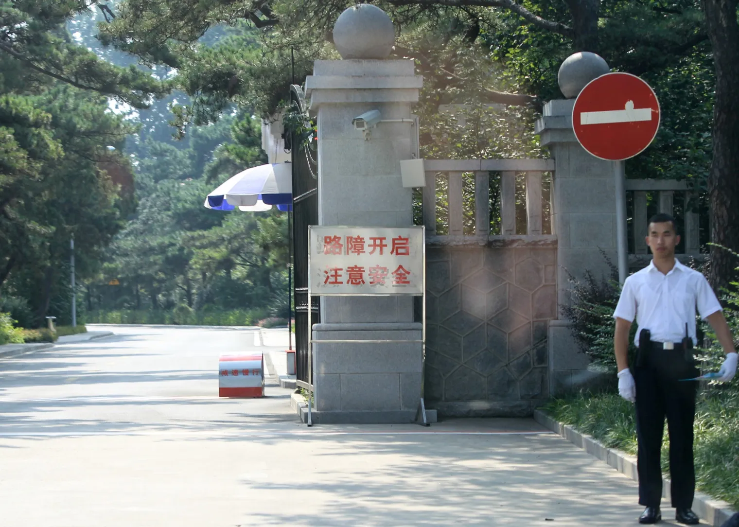 A security official stands guard outside a compound which is closed to the public in Beidaihe.
