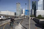 A commuter wears a protective face mask while cycling beside a concrete traffic barriers in a new temporary cycle lane on a bridge leading to the La Defense business district in Paris, on May 18.