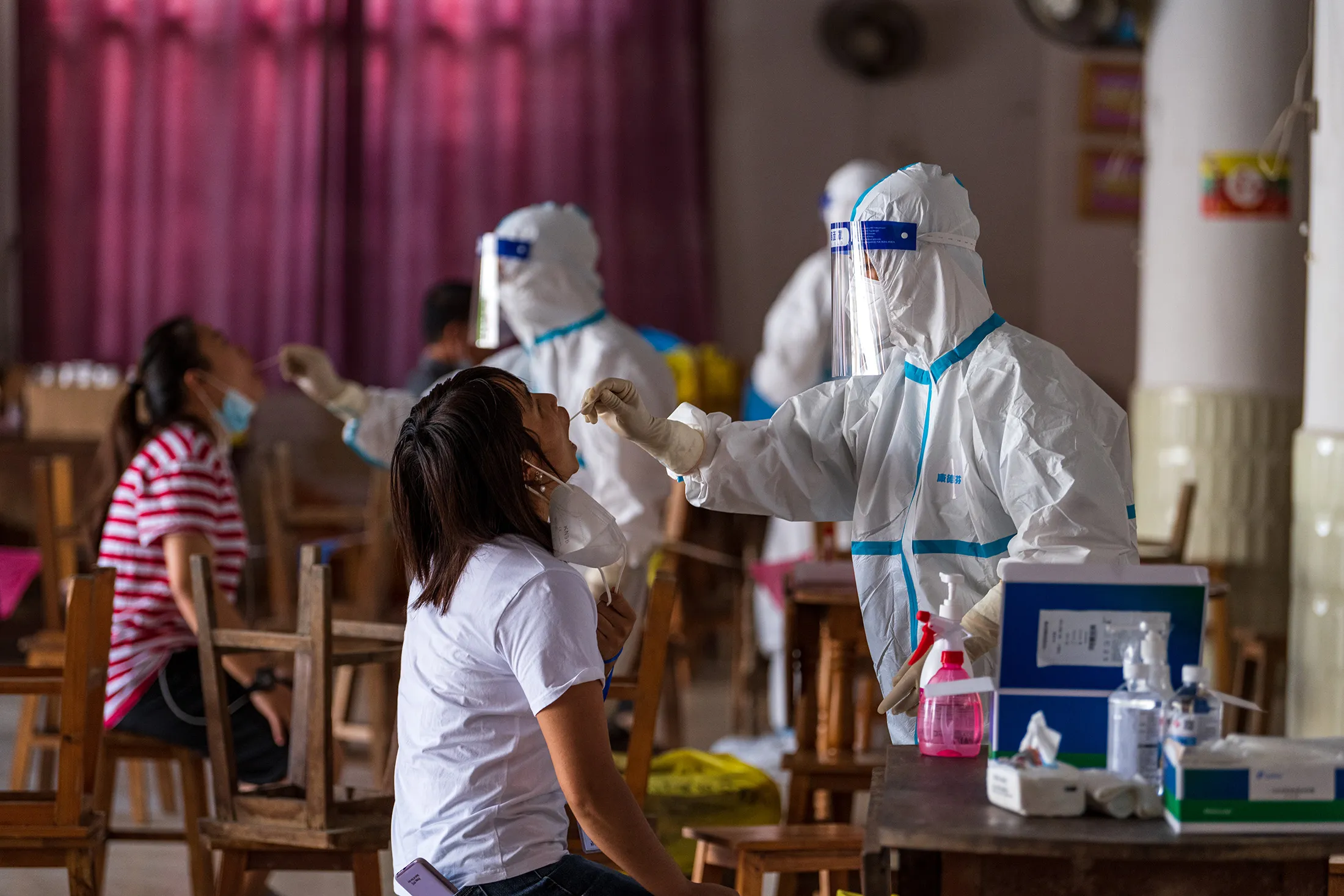 Medical workers collect throat swab from local residents at a Covid-19 nucleic acid testing site in Ruili, China, on Oct. 2.