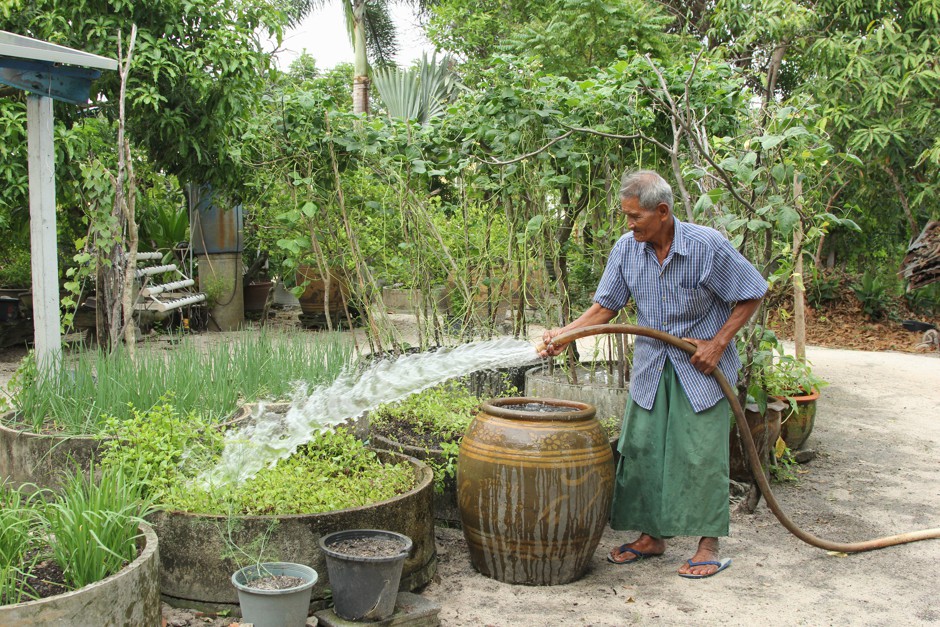 Noi Jaitang, interviewed as part of the World Resources Institute report, waters his garden in Thailand