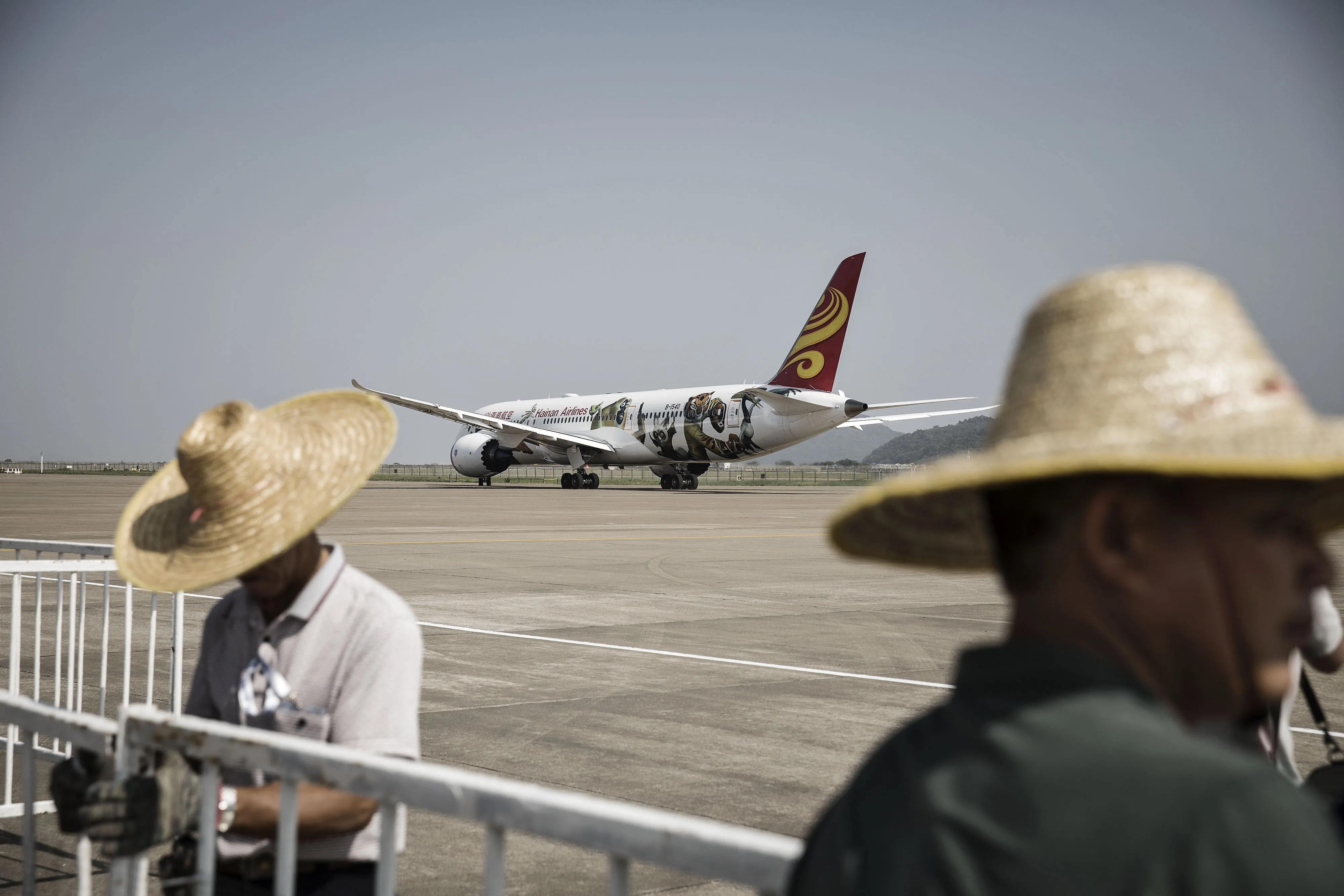Workers arrange barricades in front of a Boeing Co. 787-9 aircraft operated by Hainan Airlines Co. at the China International Aviation & Aerospace Exhibition in Zhuhai, China, on Monday, Oct. 31, 2016. The biannual air show runs from November 1 to 6.