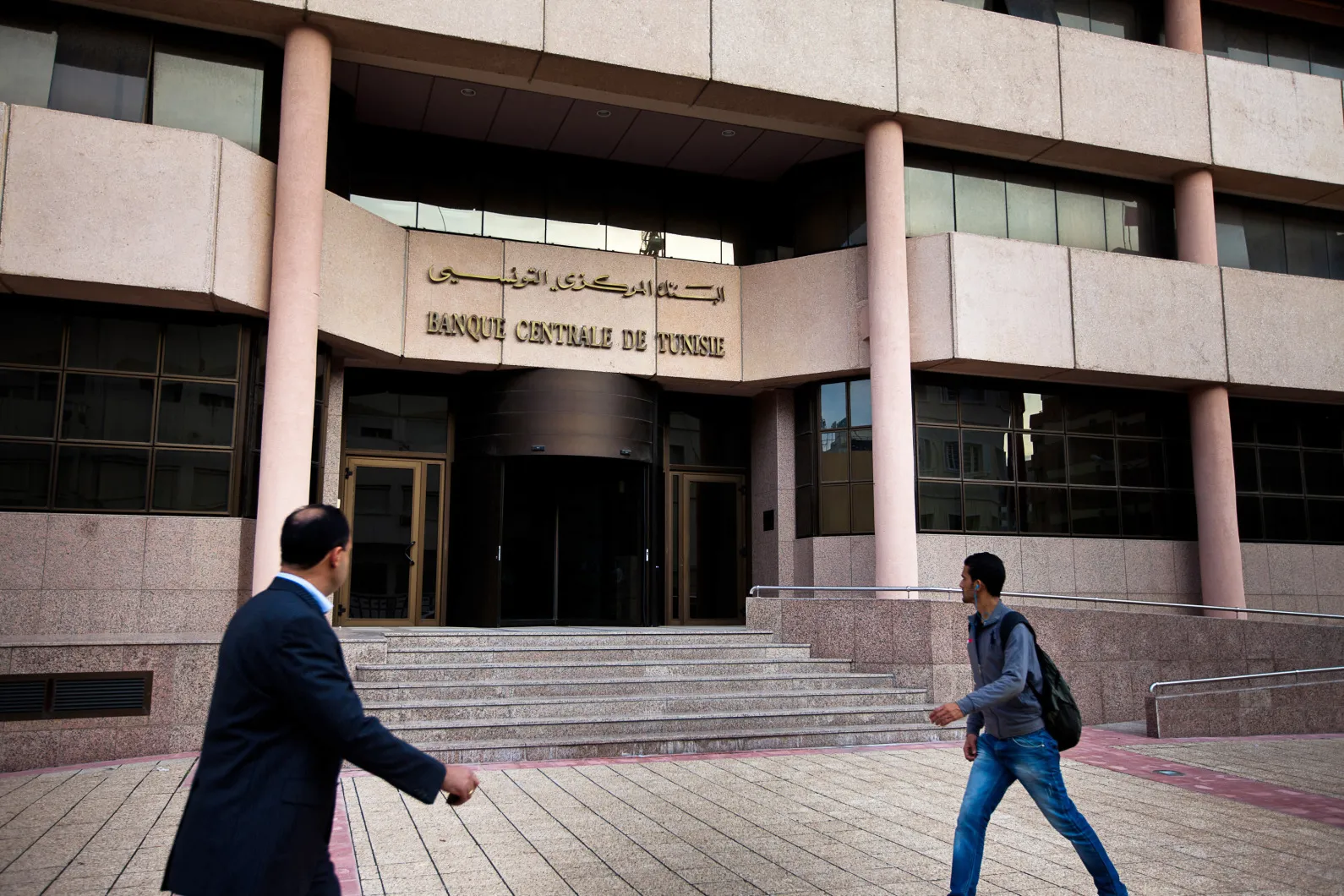 Pedestrians pass the Tunisian central bank in Tunis, Tunisia.