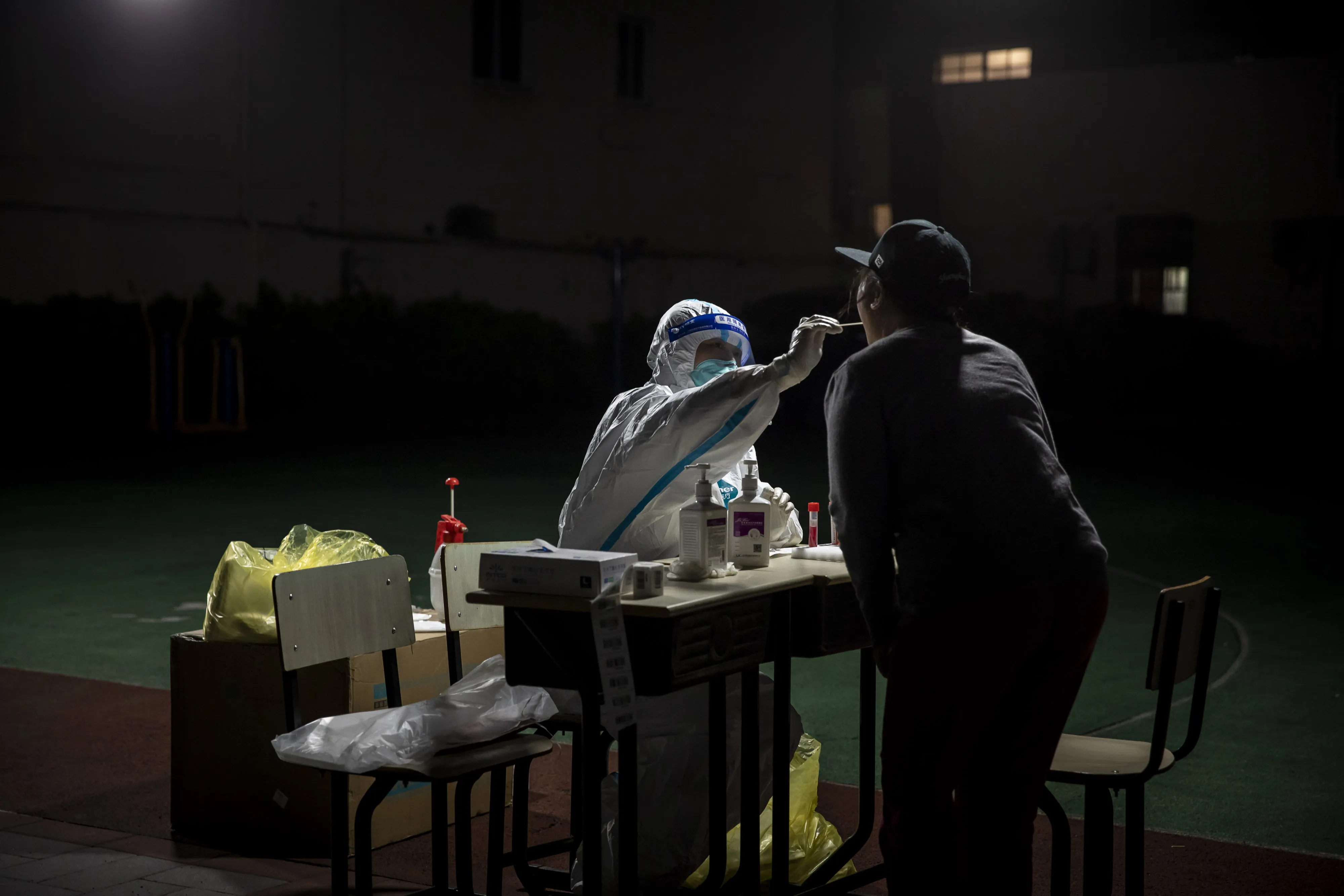 A healthworker collects swab sample from a resident for a Covid-19 test in a neighborhood placed under lockdown in Shanghai, on April 9.
