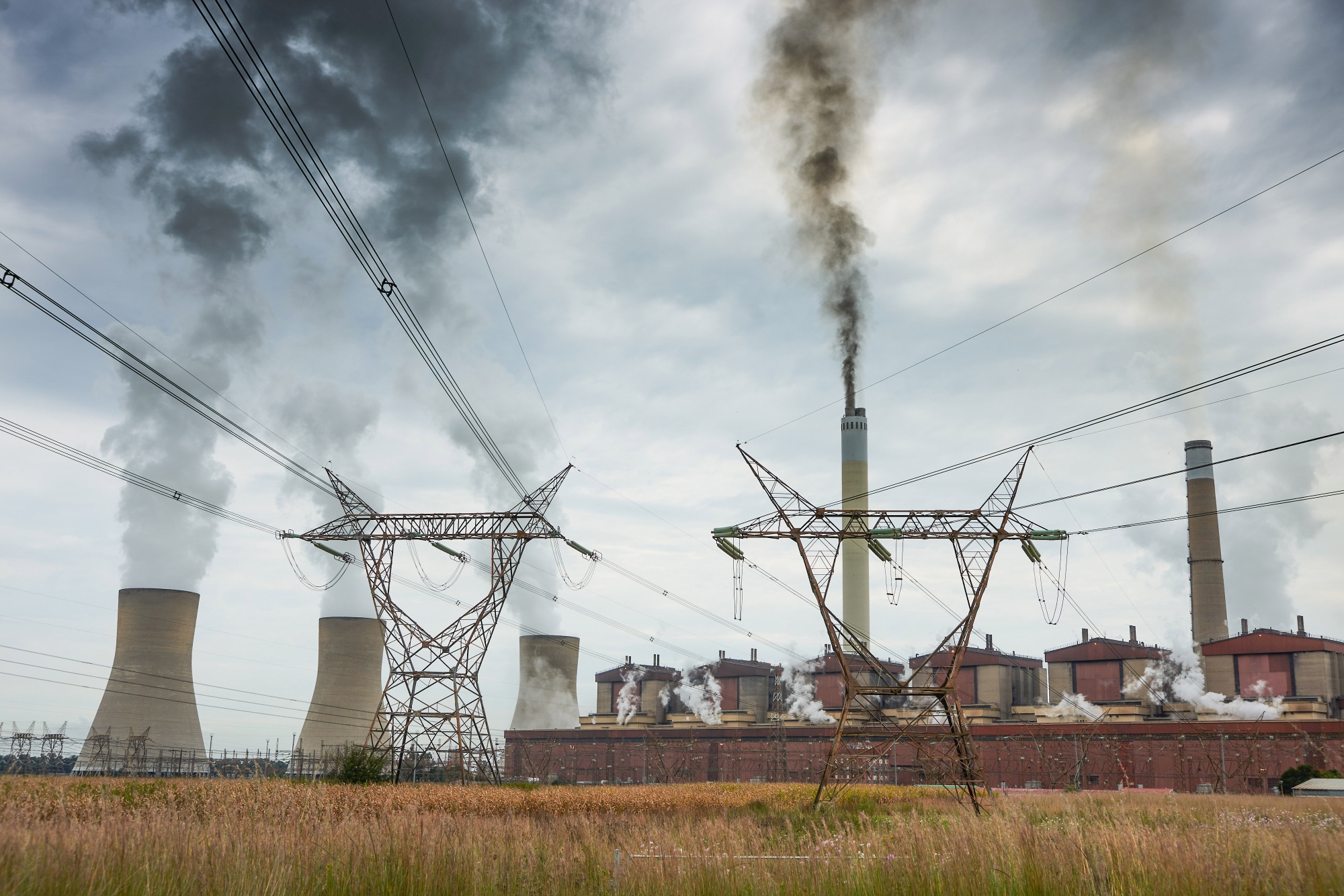 High voltage electricity transmission pylons alongside the Eskom Holdings SOC Ltd. Matla coal-fired power station in Mpumalanga, South Africa.