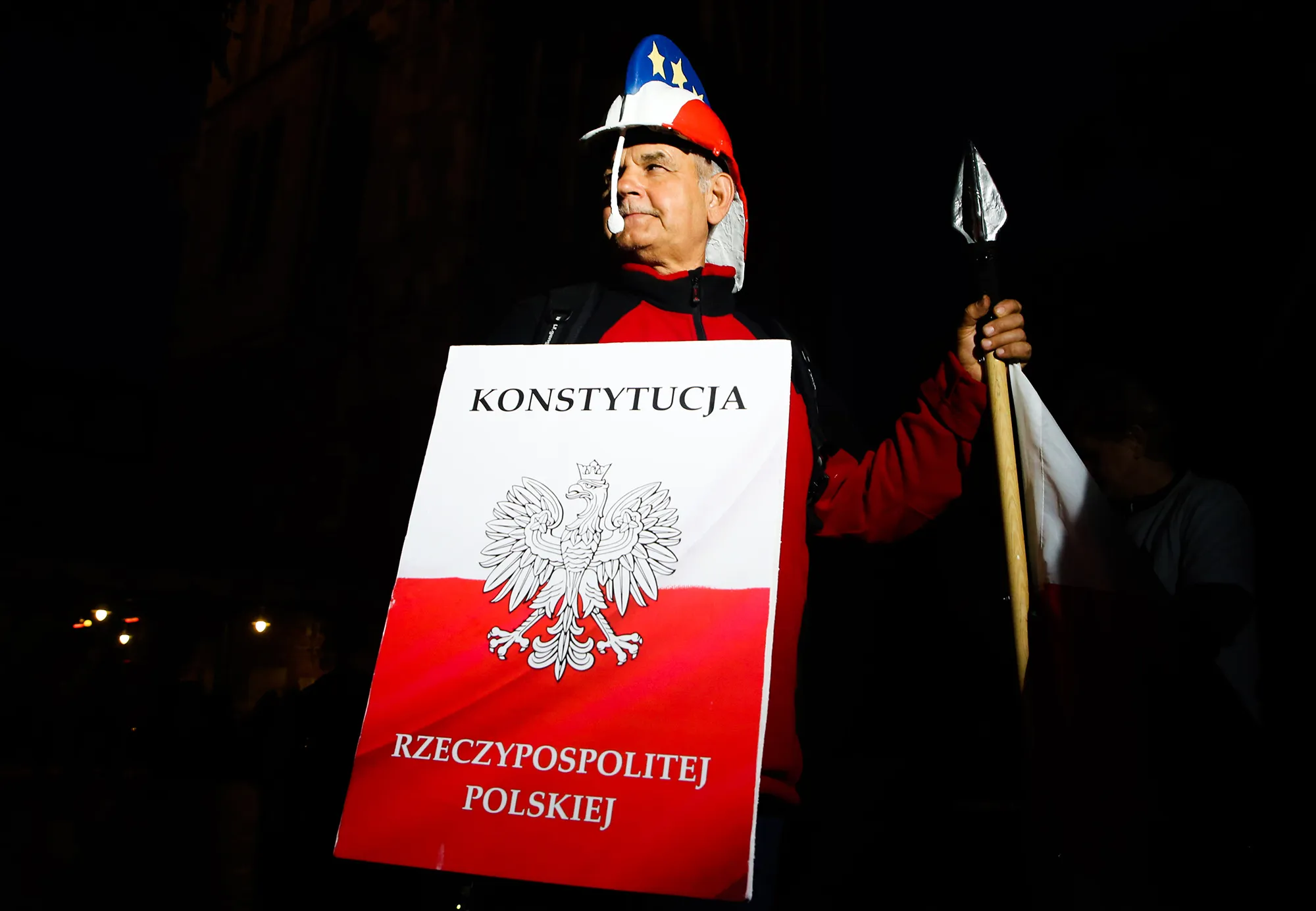 A man wearing a handmade roman helmet, shield marked 'Constitution' and spear with Polish and EU flag elements during a protest in Krakow on Sept. 22, 2018.