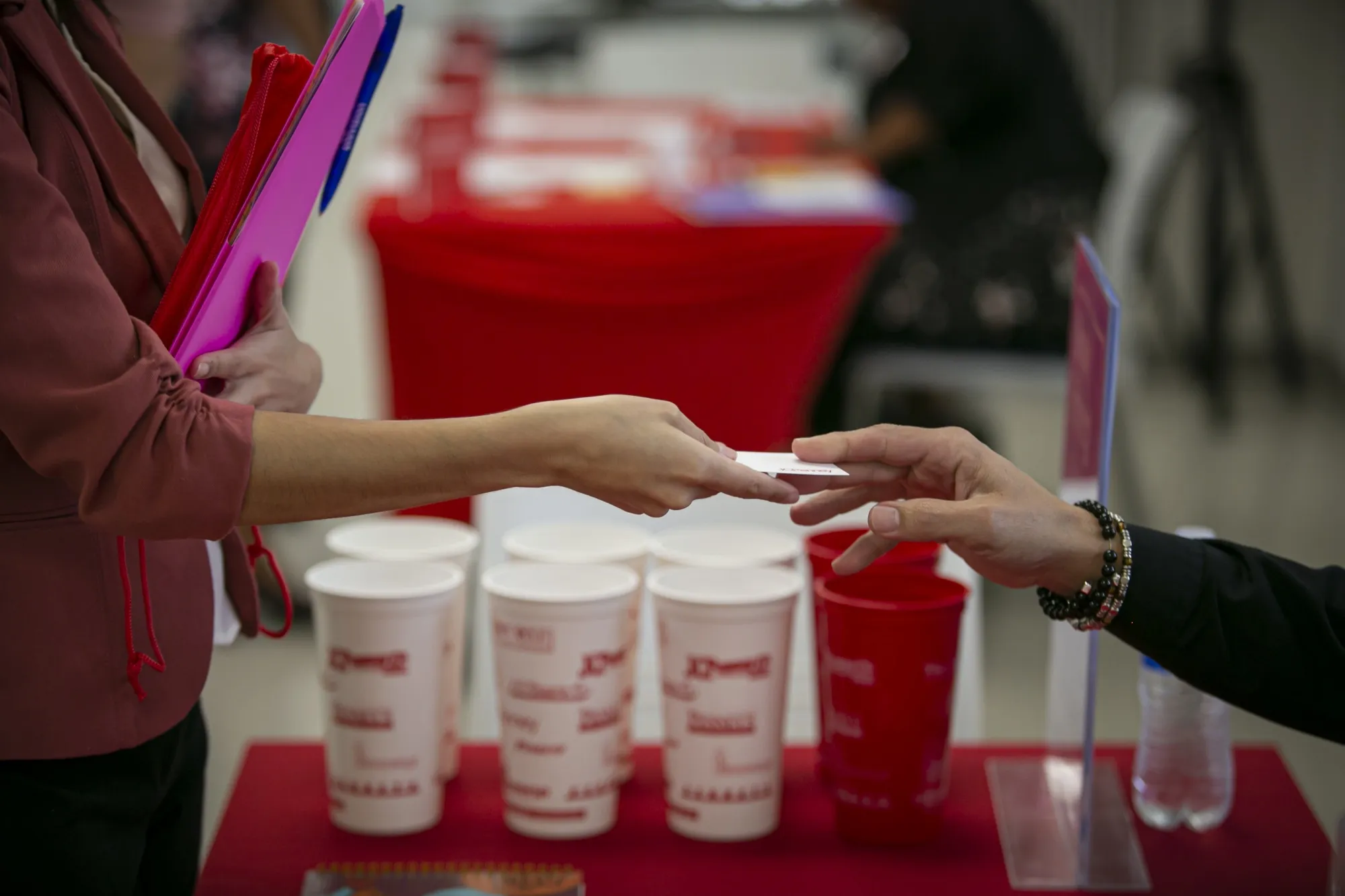 A representative hands a business card to a job seeker during a job fair&nbsp;in Miami.