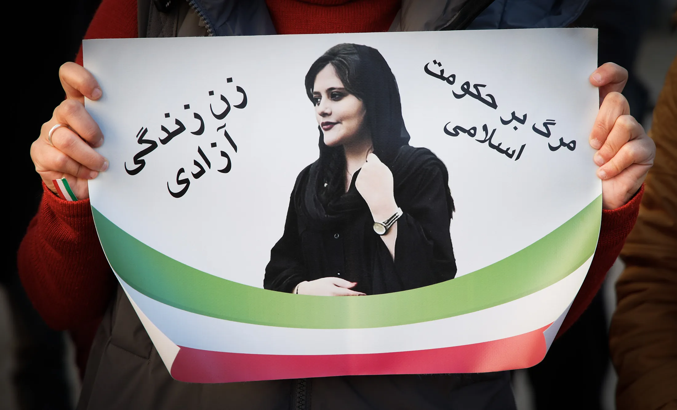 A protester holds a sign with an image of&nbsp;Mahsa Amini, a 22-year-old Kurdish Iranian woman who had been detained by police for allegedly flouting the country’s&nbsp;Islamic dress codes.&nbsp;