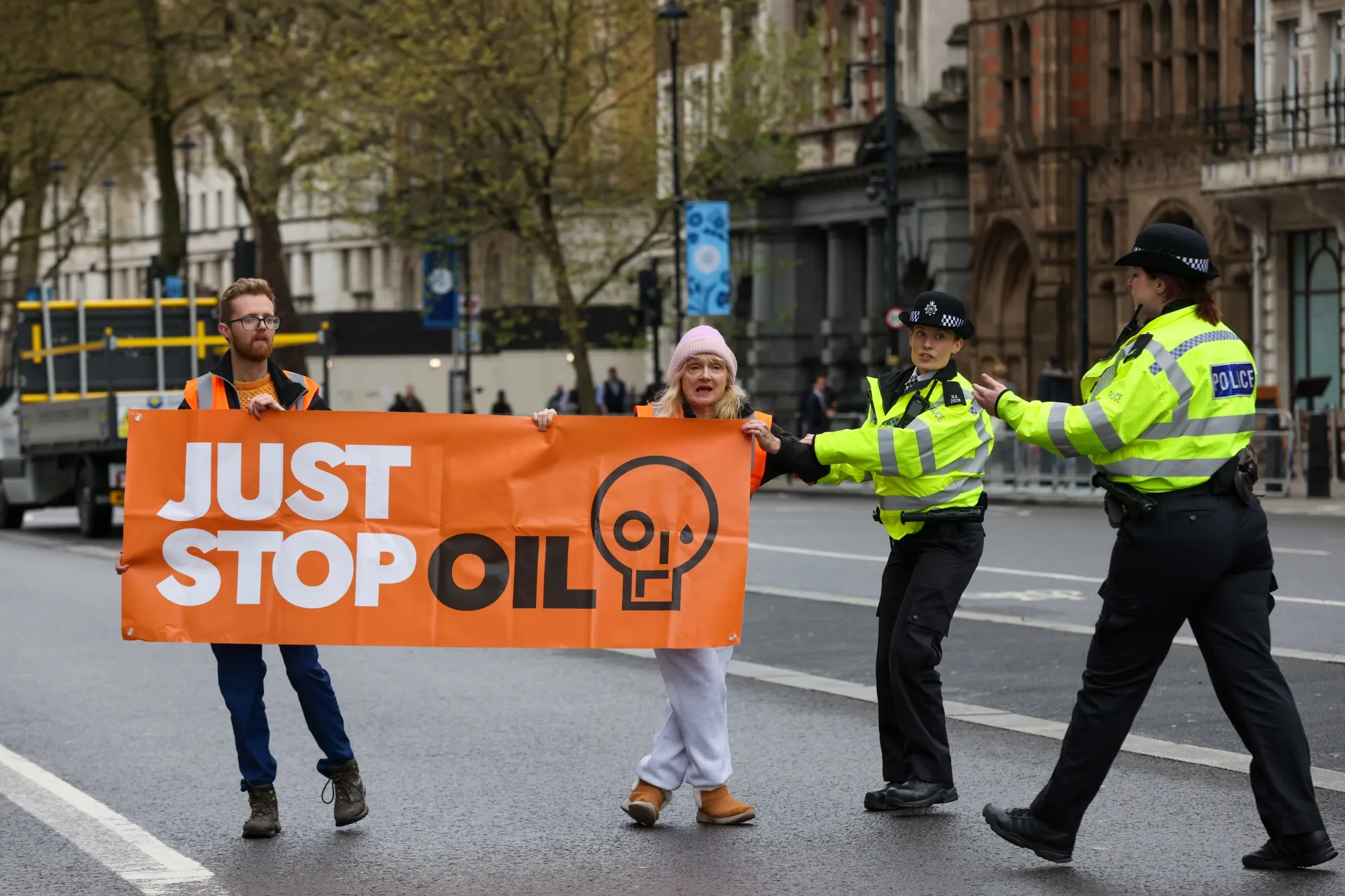 Police officers attempt to stop climate activists from Just Stop Oil blocking traffic along Whitehall in London in April&nbsp;2023.&nbsp;