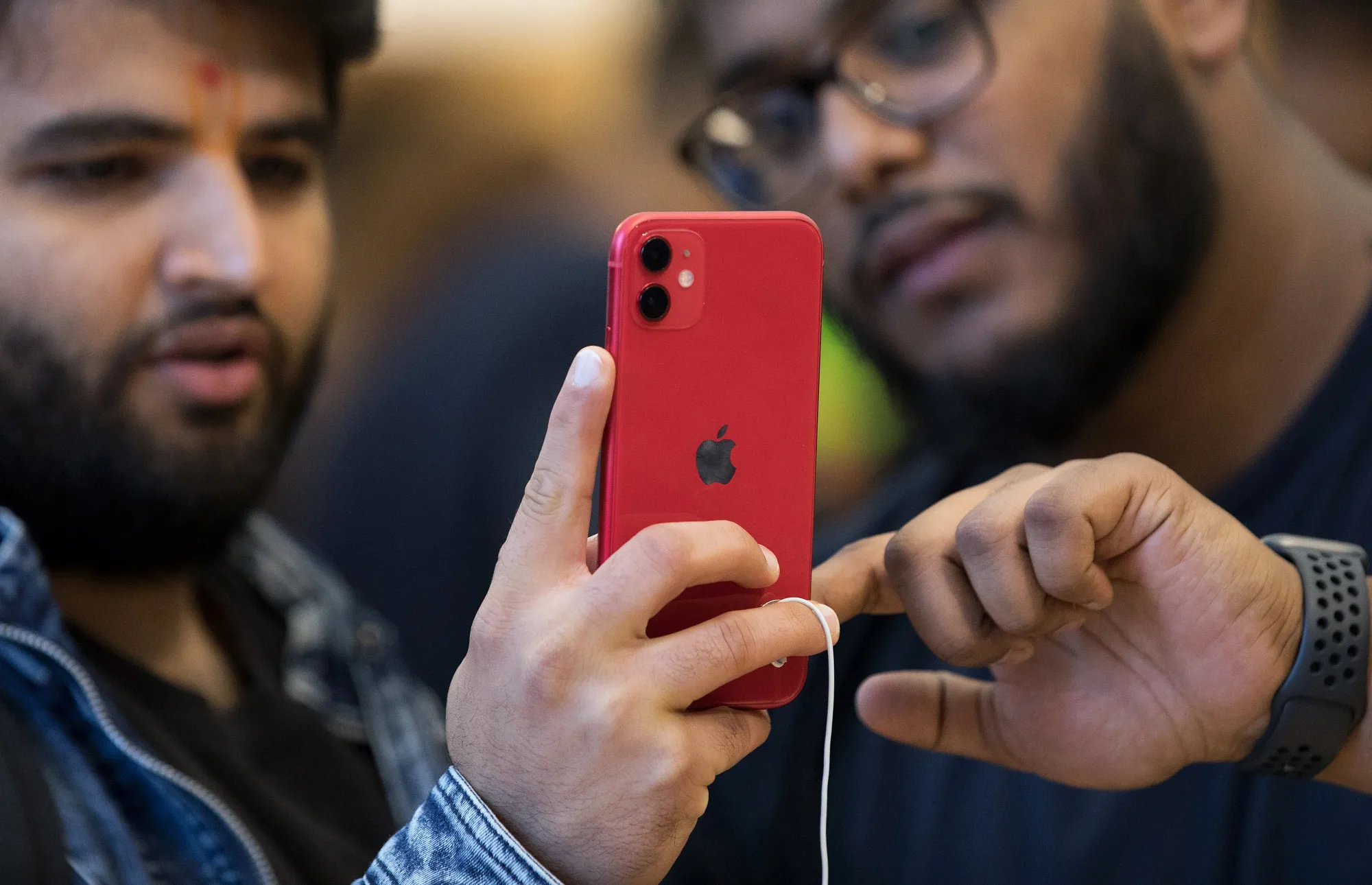 An employee, right, shows a customer the features of an iPhone 11 inside the Regent Street Apple store in London.