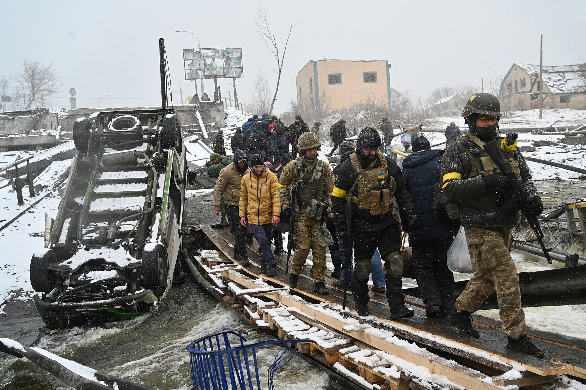 Ukrainian soldiers walk across a destroyed bridge during the evacuation of&nbsp;civilians in&nbsp;the city of Irpin, northwest of Kyiv, on March 8.
