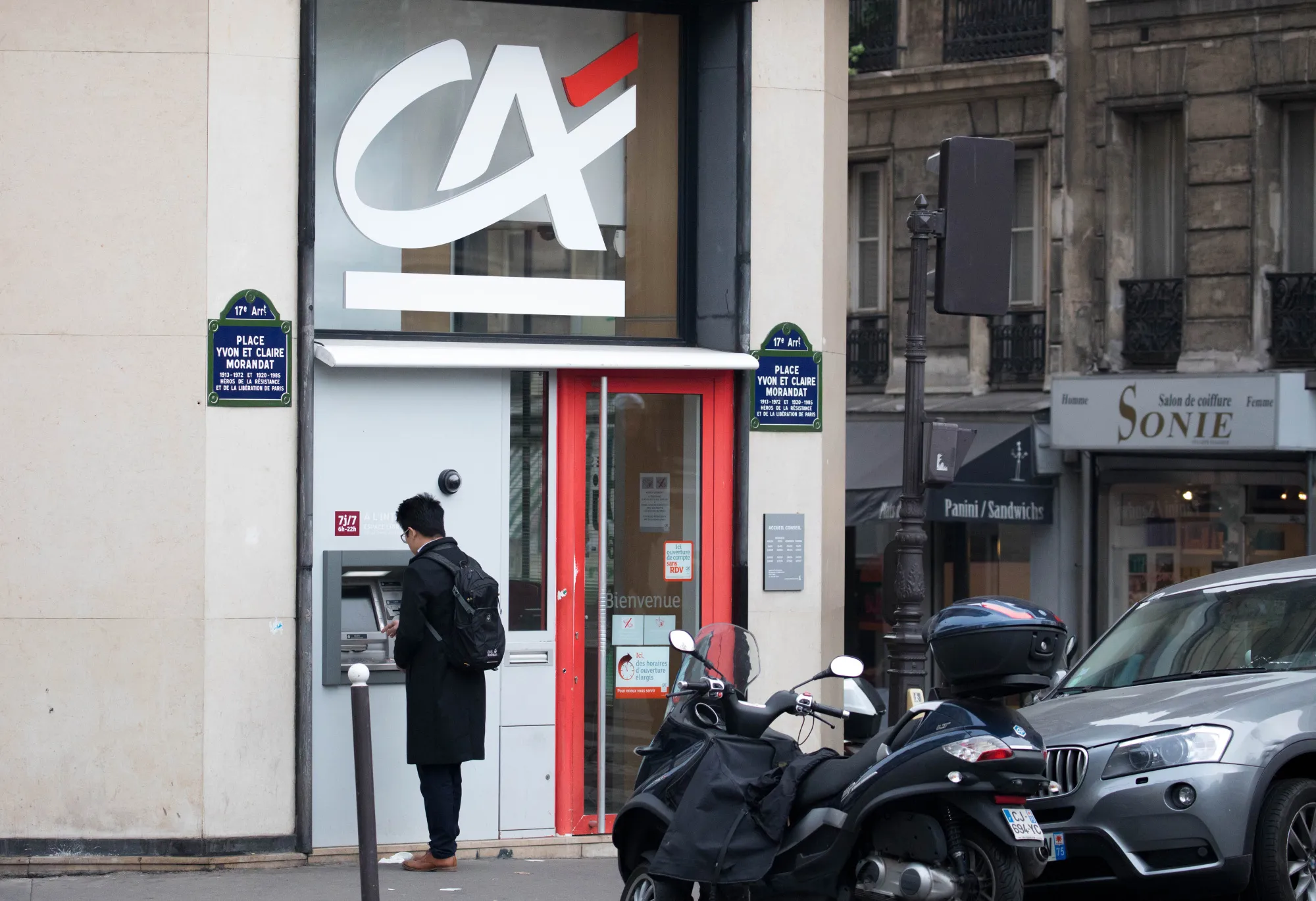 A customer uses an automated teller machine outside a Credit Agricole SA bank branch in Paris, France.