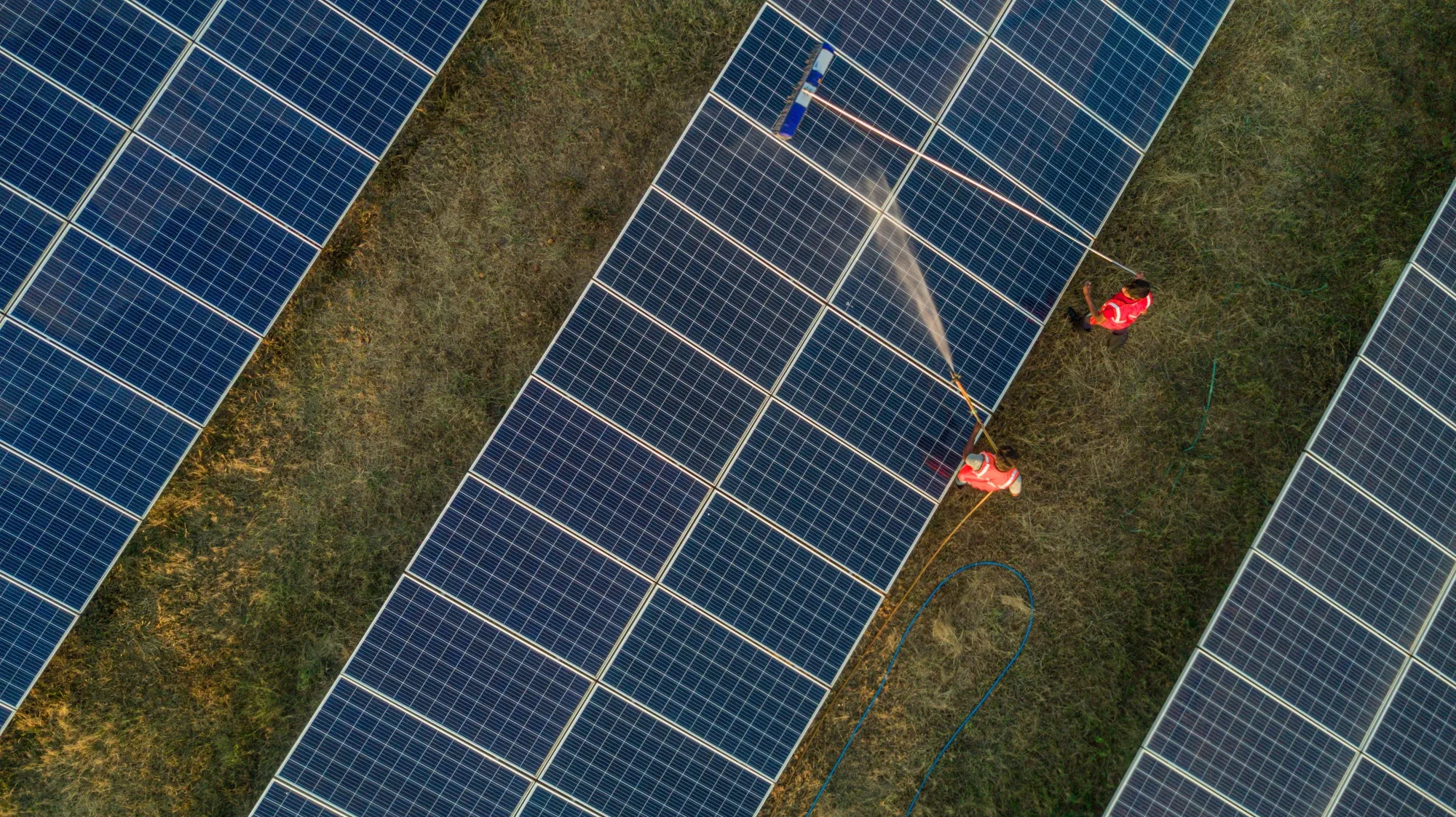 Workers wash photovoltaic panels at a solar farm in Pavagada, Karnataka, India.