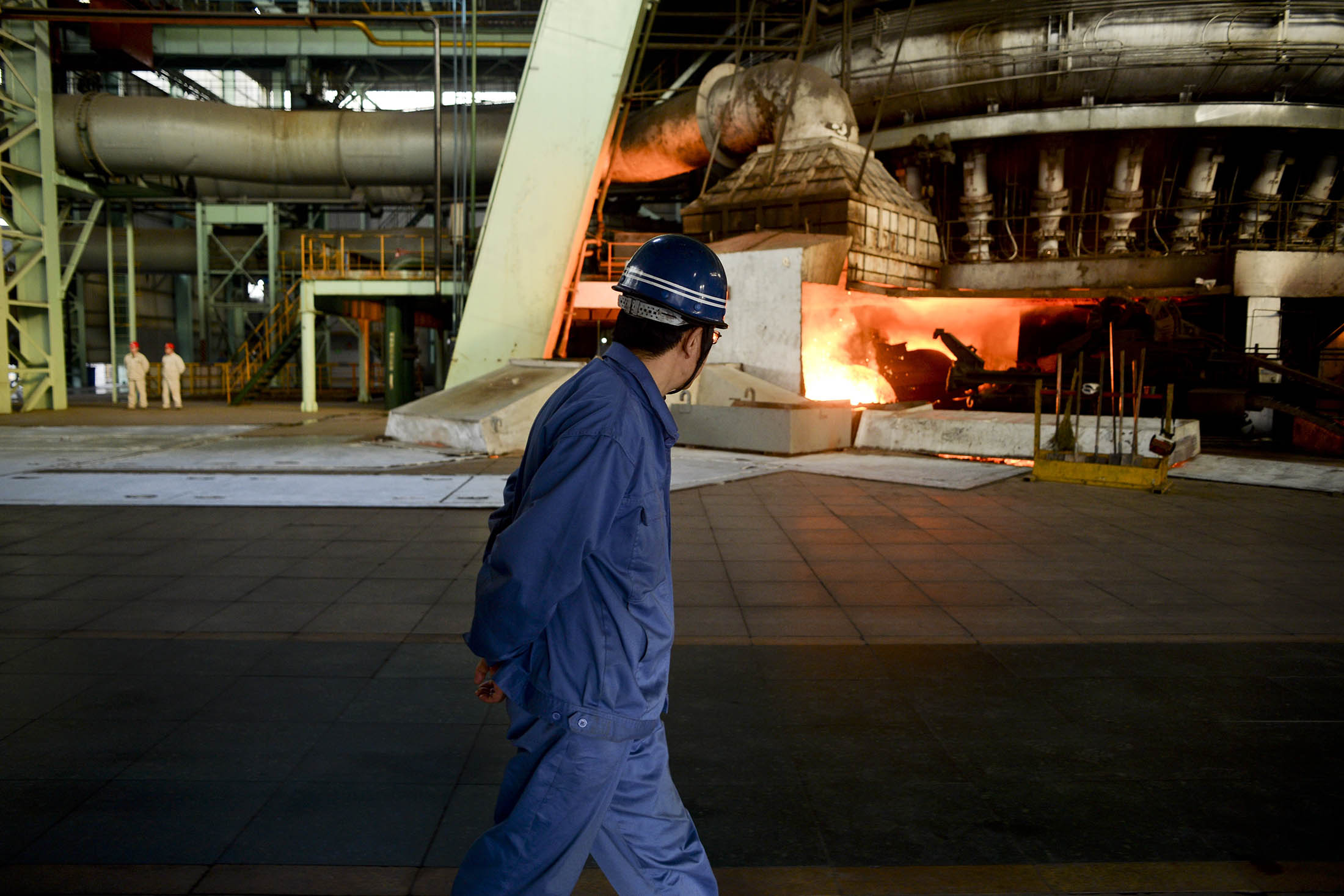 A worker walks past a furnace at a steel plant in China's northern Hebei province.
