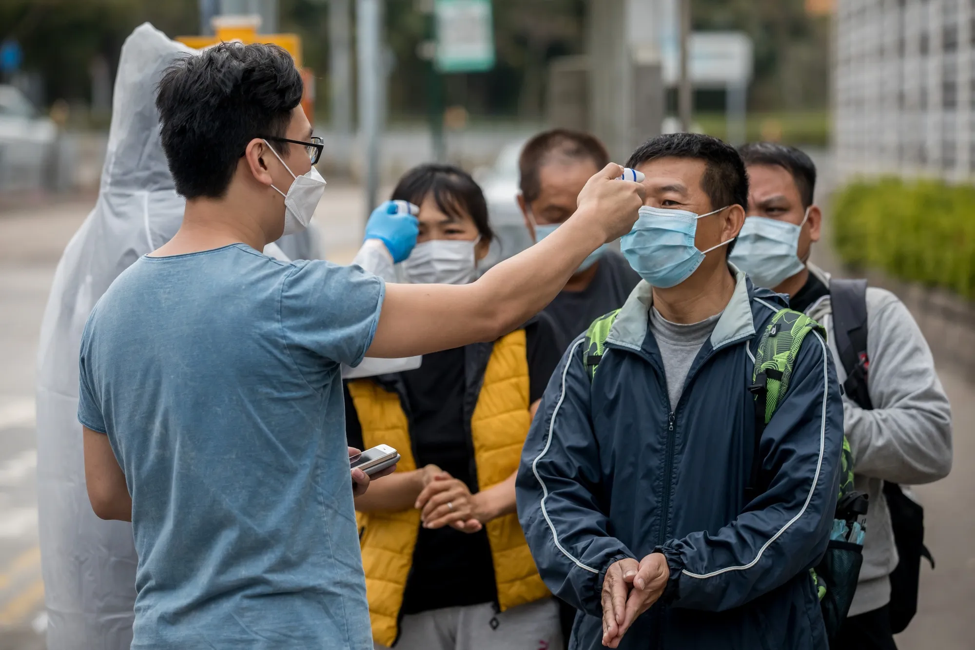 Passengers have their temperatures checked at a civilian screening point after disembarking from buses, including those traveling from the Shenzhen Bay border-crossing, in Hong Kong, on Feb. 4.