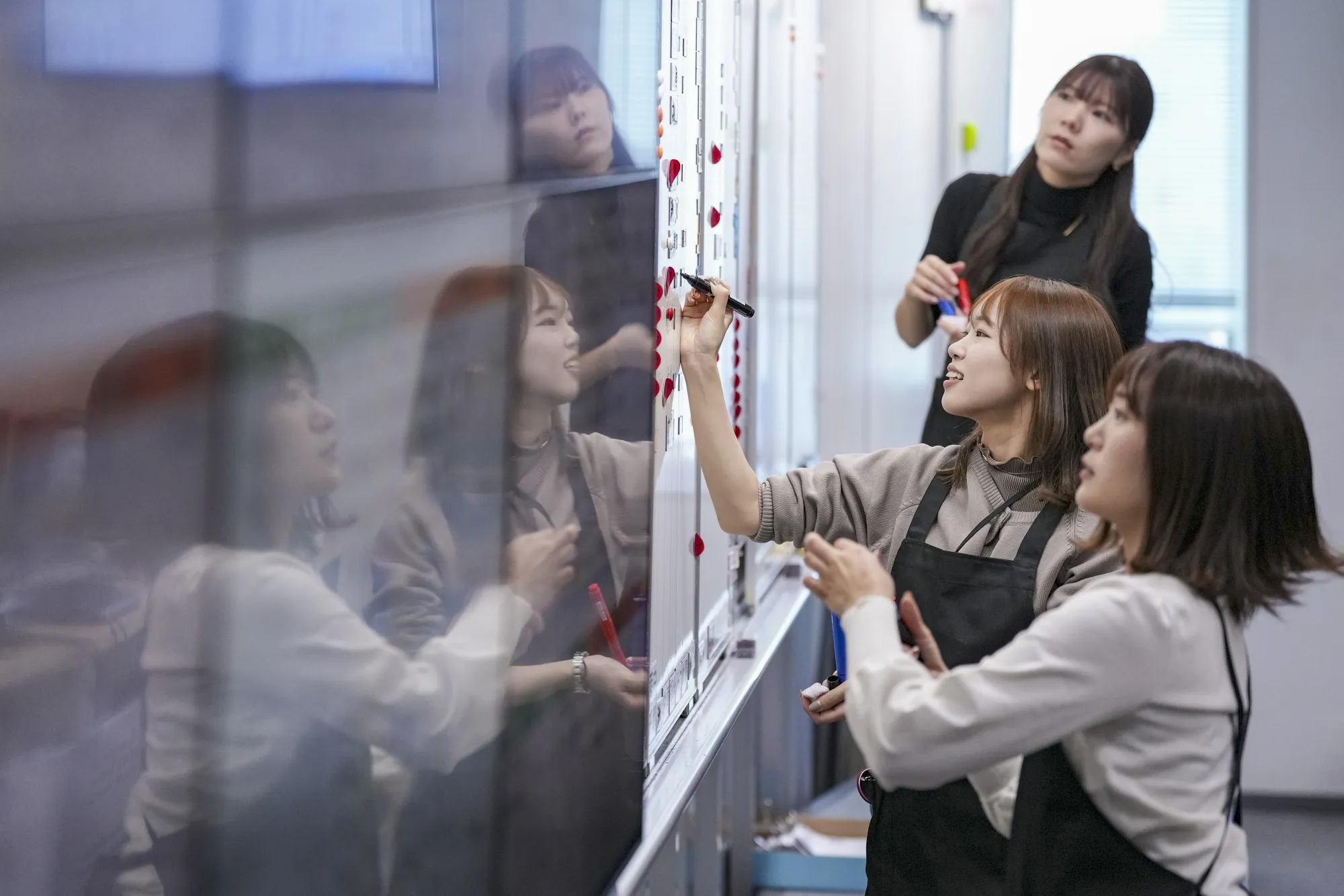 Workers write information down on a whiteboard at a trading floor of Tokyo Tanshi Co., a major inter-dealer broker, in 2023.