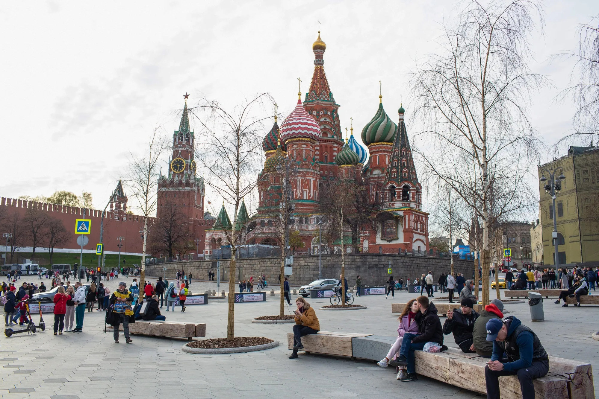 Visitors walk by the Spasskaya tower of the Kremlin and Saint Basil's Cathedral in Moscow.