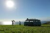 Family with camper in field by sea