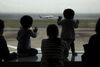 Children watch an All Nippon Airways Co. (ANA) aircraft taking off at Haneda Airport in Tokyo, Japan.