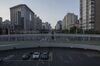 A woman walks across a pedestrian overpass as buildings stand in the background in Beijing, China, on Thursday, July 26, 2018. Beijing residents have been breathing some of the cleanest air in a decade as they begin to reap the benefits of China's anti-smog push.