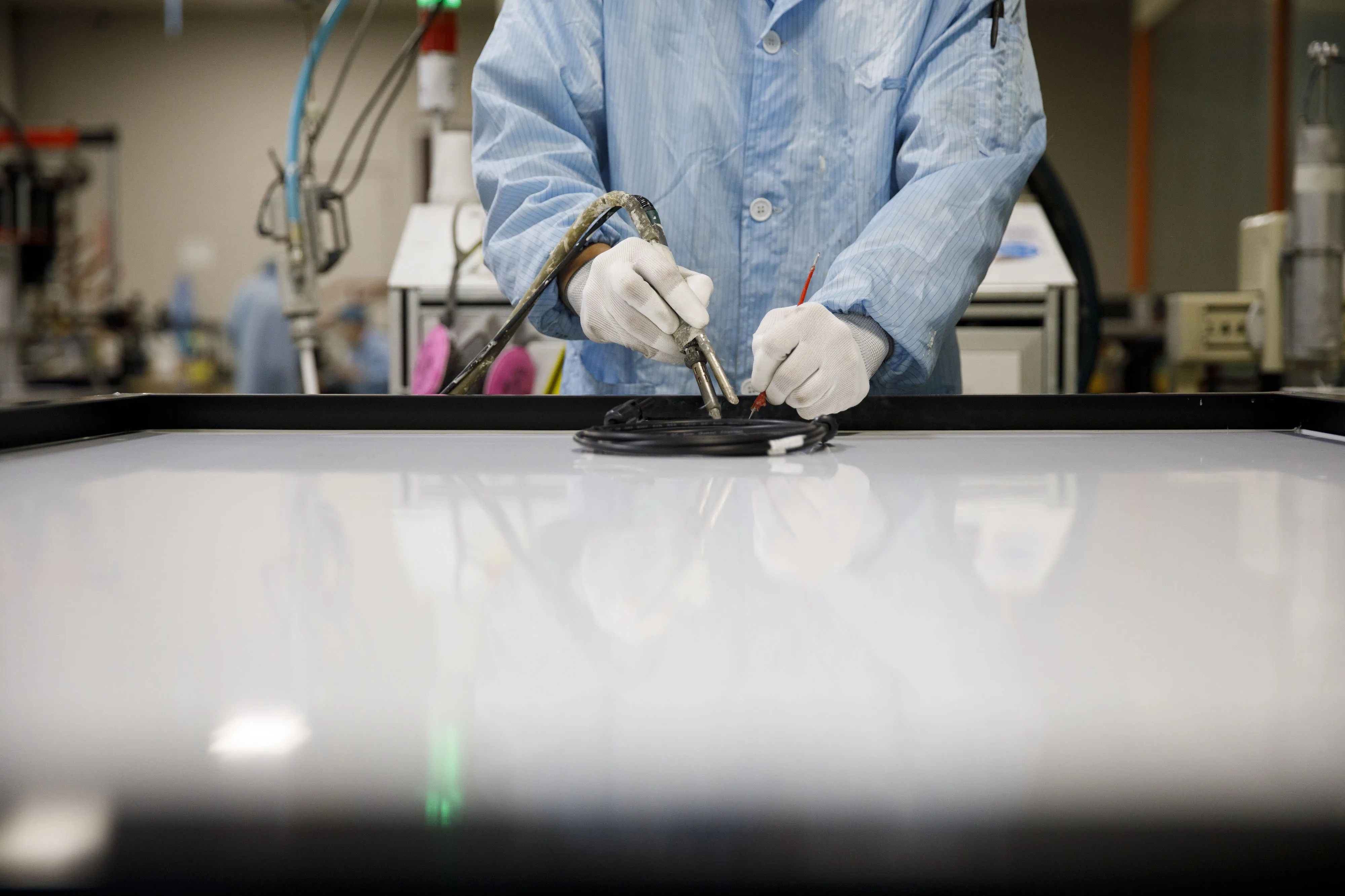 A worker installs a component during production at the SunSpark Technology Inc. manufacturing facility in Riverside, California, U.S., on Tuesday, April 3, 2018.