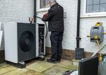 A serviceman works on a heat pump unit at a home in Folkestone, United Kingdom.