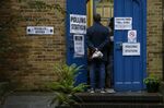 Voters stand in line at a polling station in London on Dec. 12.